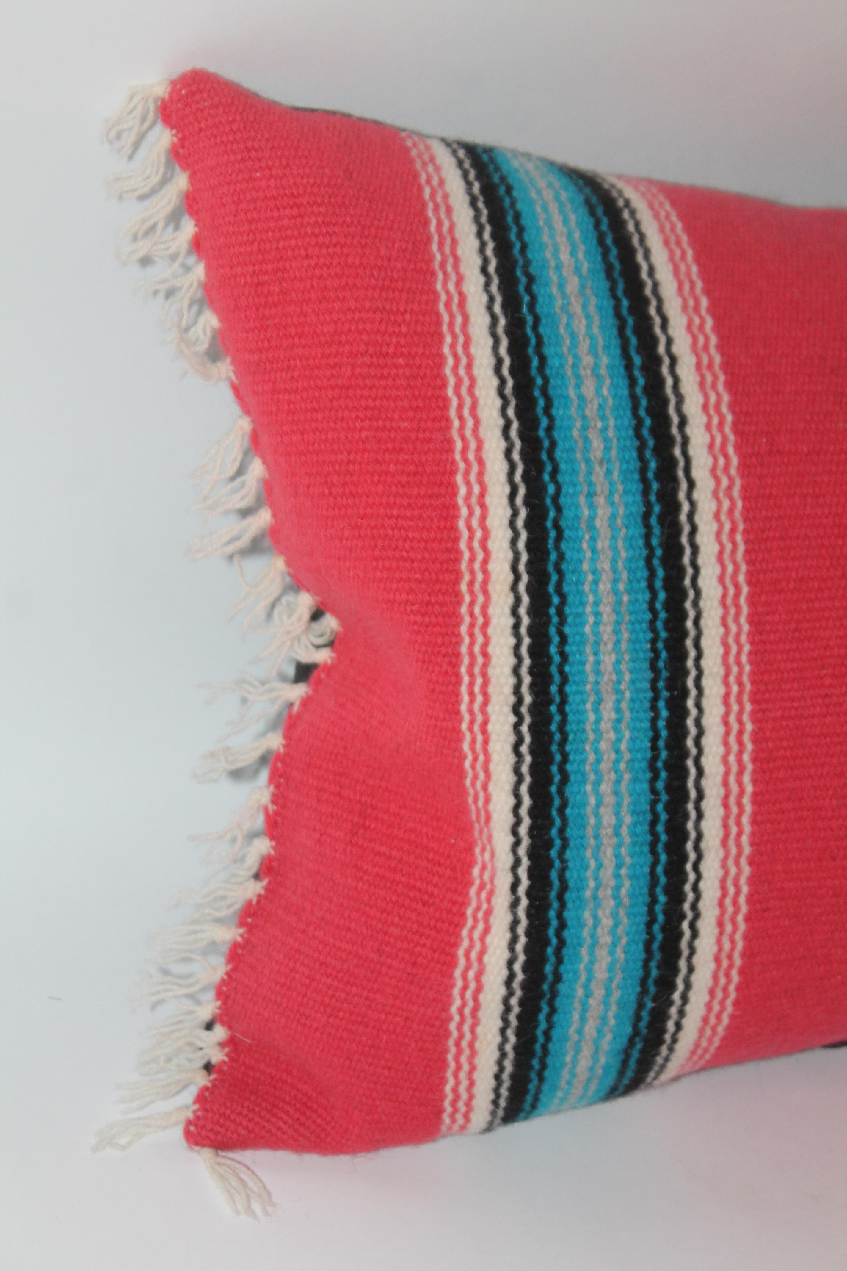 Insolito serape con colori bellissimi e brillanti. Il tono rosso sbiadito mostra le sorprendenti linee turchesi in una forma vibrante ed elegante.