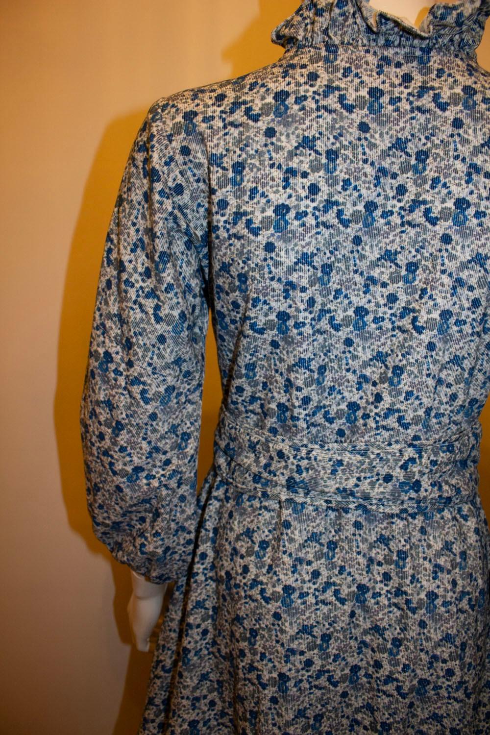 A pretty and practical dress for Spring by Seraphina of London. The dress is in  a light weight corduroy with a pretty blue floral print. The dress is lined in cotton and hangs beautifully. It has a frill collar, button front opening with pin tucks,