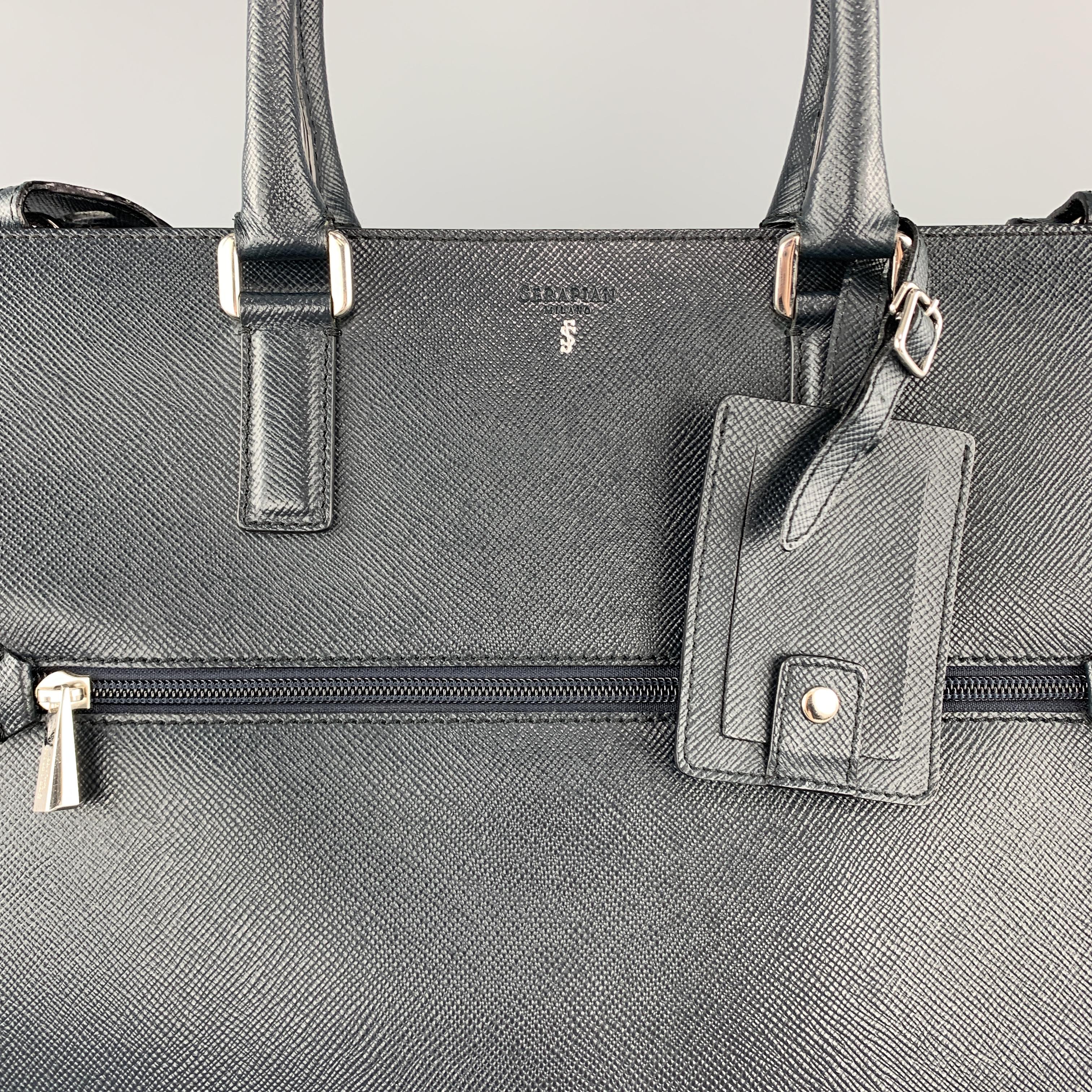 SERPIAN satchel tote bag comes in navy blue Saffiano textured leather with silver tone hardware, zip pocket, double rolled top handles, luggage tag,  top zip, detachable strap, and double compartment interior with center zip pocket divider. Minor