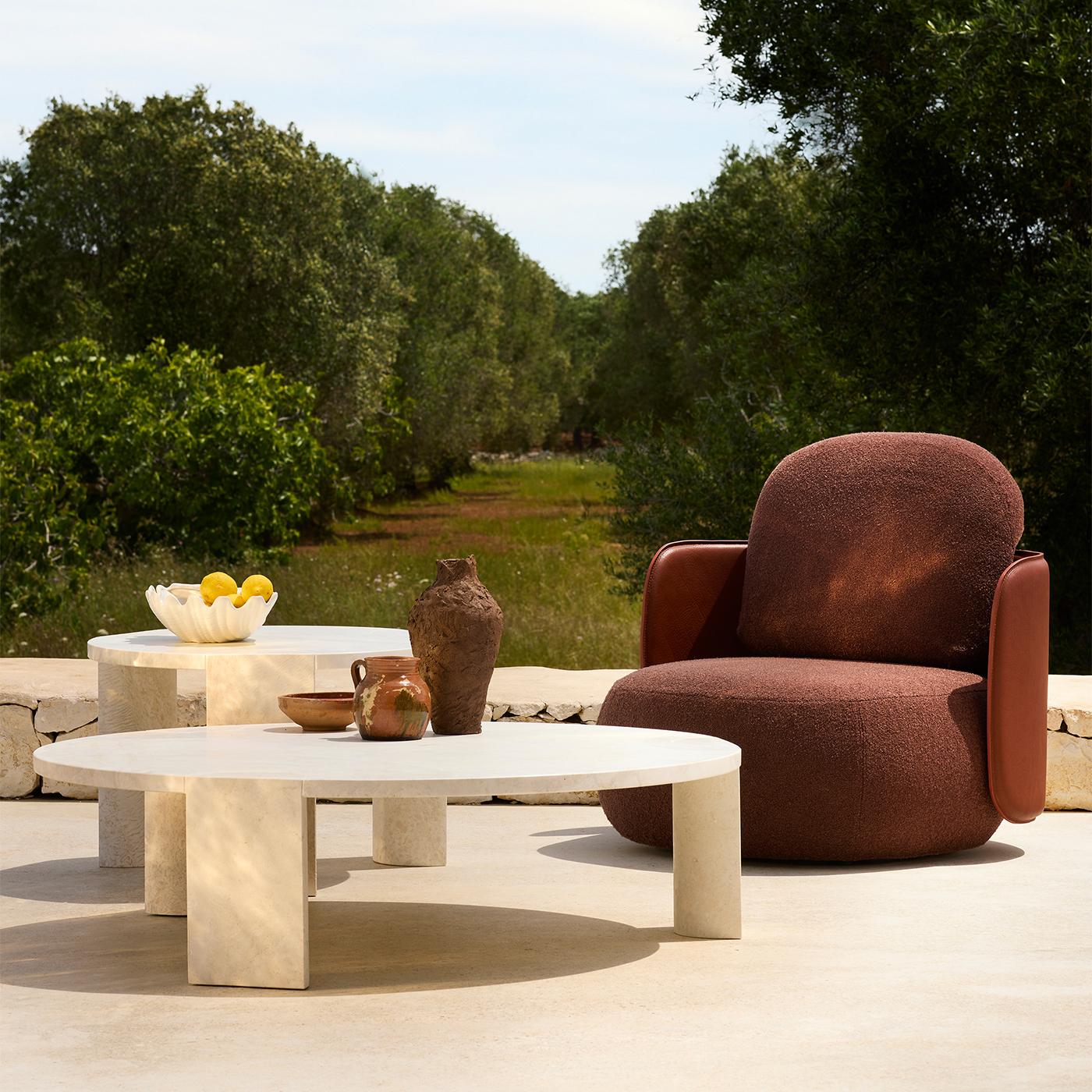 Des teintes délicates et des volumes géométriques définissent l'esthétique sculpturale raffinée de cette table basse, la suggérant comme un complément idéal aux espaces professionnels ou résidentiels contemporains. Disponible en marbre ou en pierre
