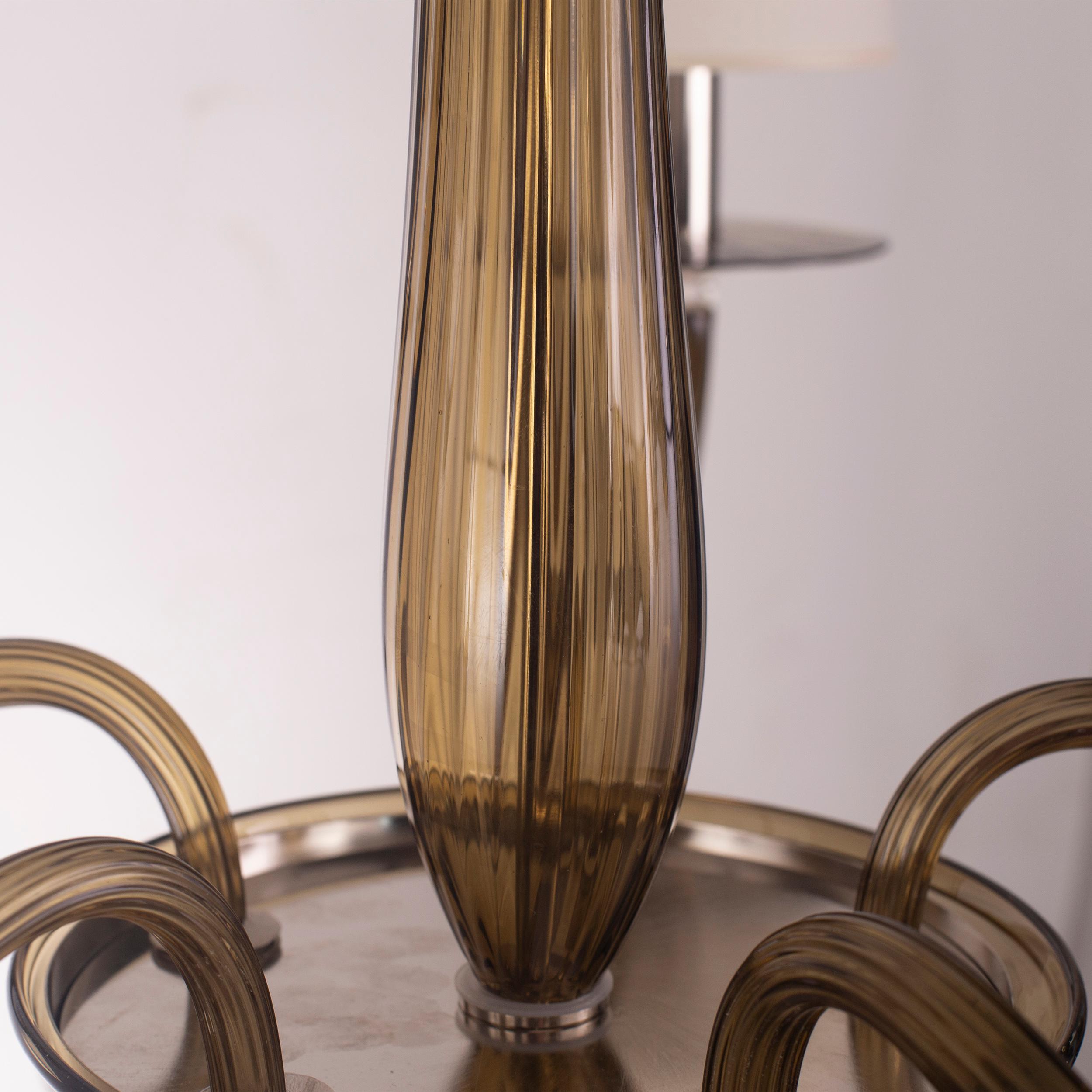 Serenade 6-armiger Kronleuchter aus walnussfarbenem Glas.
Die handwerkliche Seele unserer Beleuchtungsprodukte wird jedes Mal neu erfunden, wenn wir ein neues Projekt beginnen, wenn wir mit technischen Anforderungen und individuellen Wünschen von