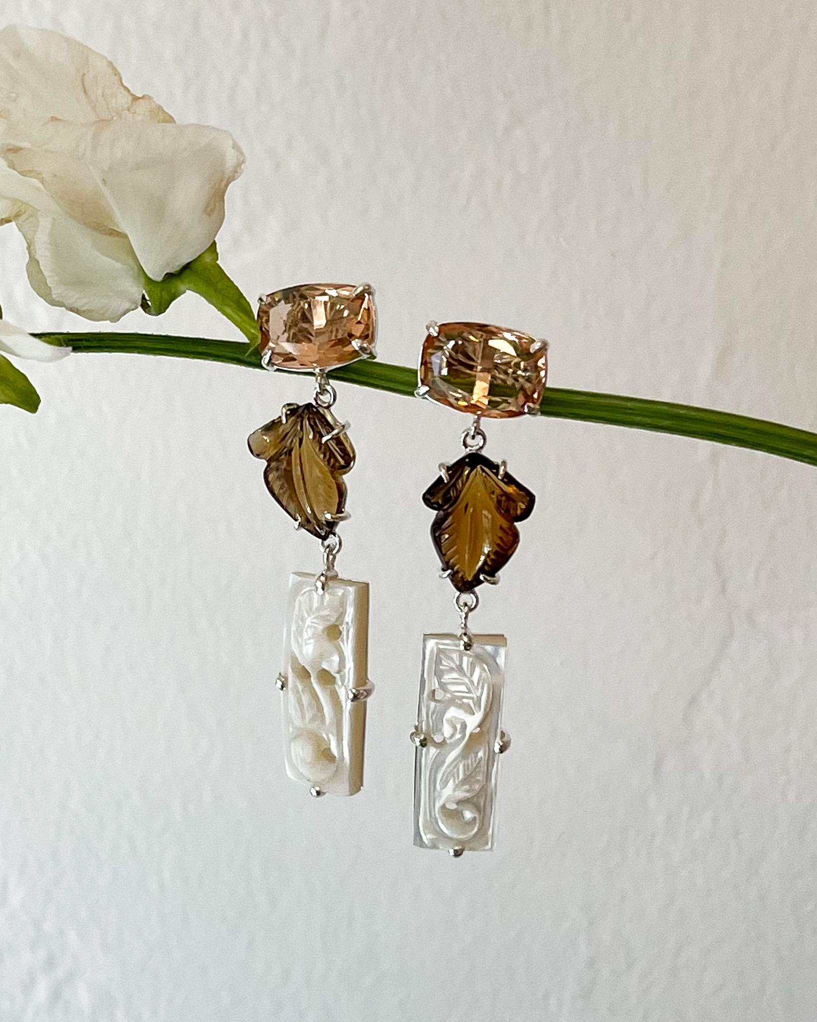 Intention: Easy breezy 

Design: Against the backdrop contemporary life, there's something calming about this design. Cushion cut morganite quartz pairs with hand-cut cognac quartz and a narrow strip of hand-cut mother of pearl. A leaf motif is