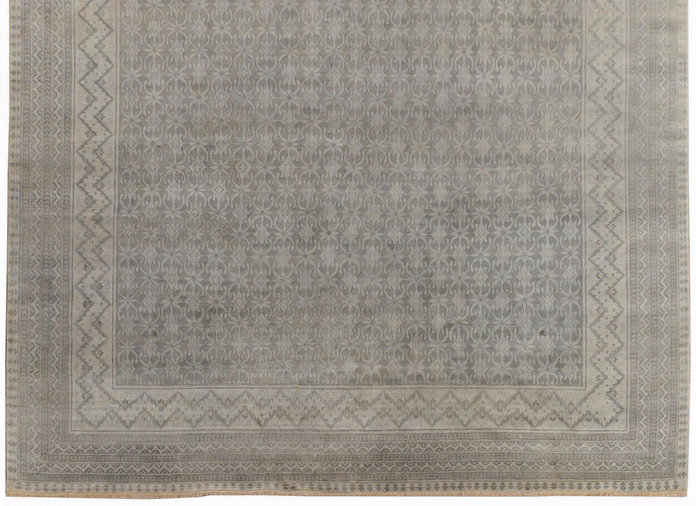 A beautiful and serene palatial size Indian Khanna rug woven with an all-over trellis floral pattern woven in varying shades of gray, and surrounded by several wide and narrow floral patterned stripes woven in similar grays as the field.