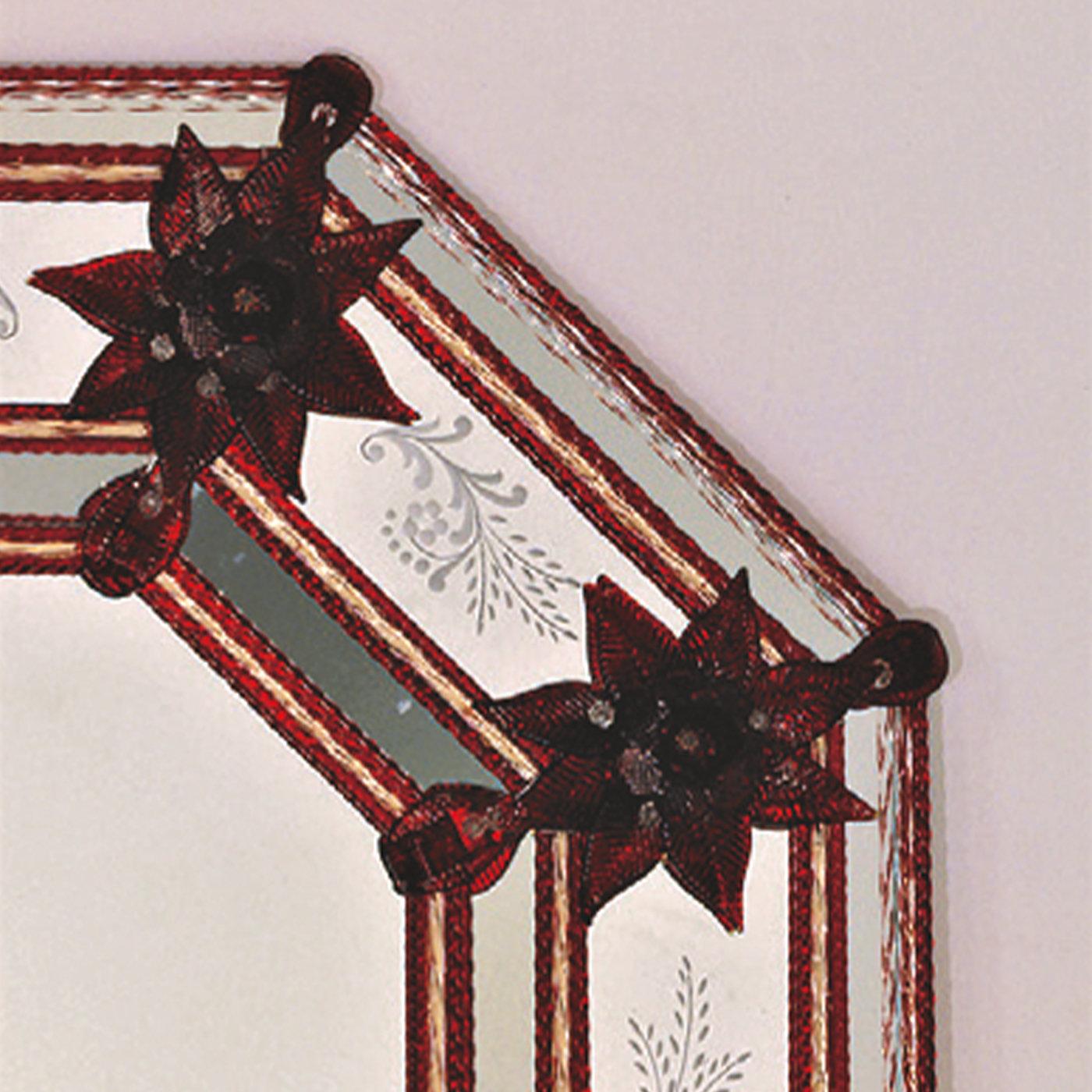 Dieser Spiegel ist reich an einzigartigen Details, die von der Kunstfertigkeit der Glasmeister aus Murano zeugen. Rote Glasblumen, Blätter und Konturlinien akzentuieren den länglichen achteckigen Rahmen, der mit fein handgeätzten Wedelmotiven