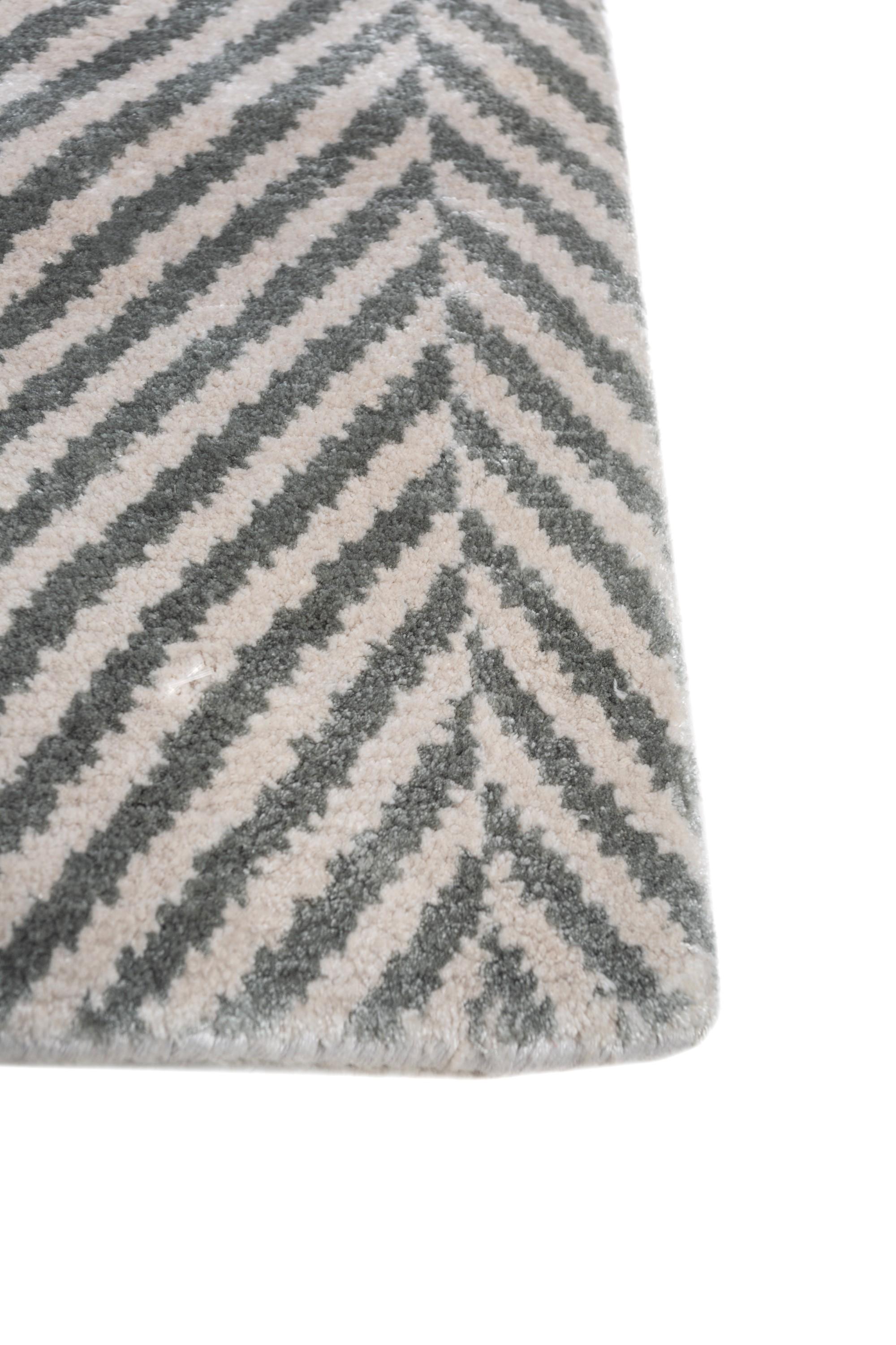 Ever wished to elevate your space with a tone-on-tone masterpiece that instantly uplifts the mood? Meet this hand-knotted rug , meticulously crafted in rural India. In a tone-on-tone palette with a white ground and aquatic border, this modern rug