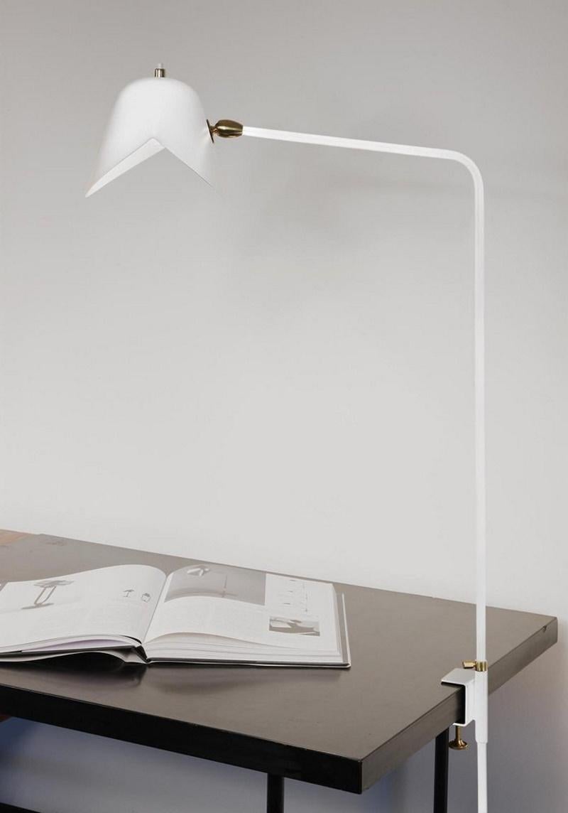 Lampe de bureau Clamp. Avec une hauteur de 26 pouces, cette lampe peut se fixer sur de nombreuses surfaces et fournir un éclairage direct là où il est nécessaire.

Disponible en blanc ou en noir. Des rotules en laiton relient les