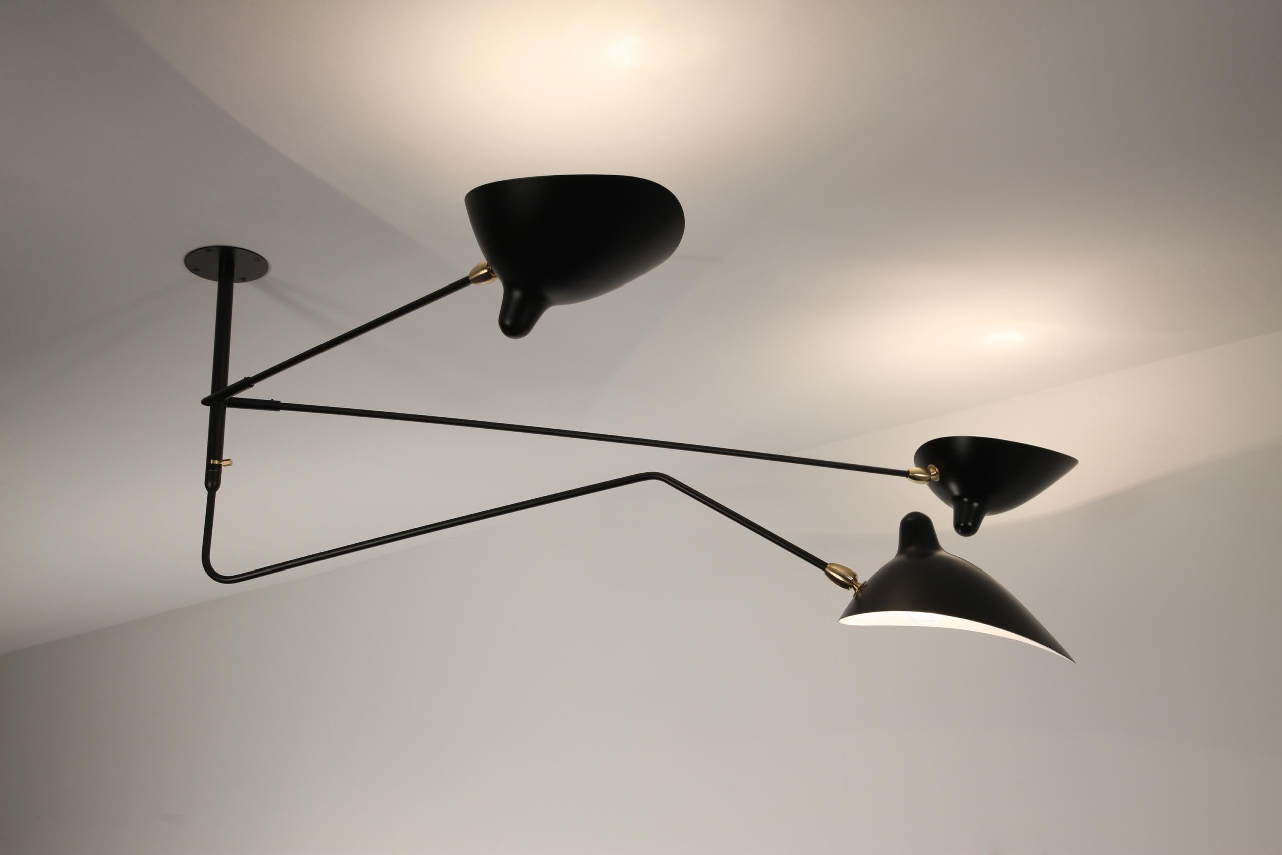 Serge Mouille 'Deux Bras Fixes Un Courbe Pivotant' ceiling lamp in black.

Originally designed in 1956, this iconic ceiling lamp is still made by Edition Serge Mouille in France using many of the same small-scale manufacturing techniques and