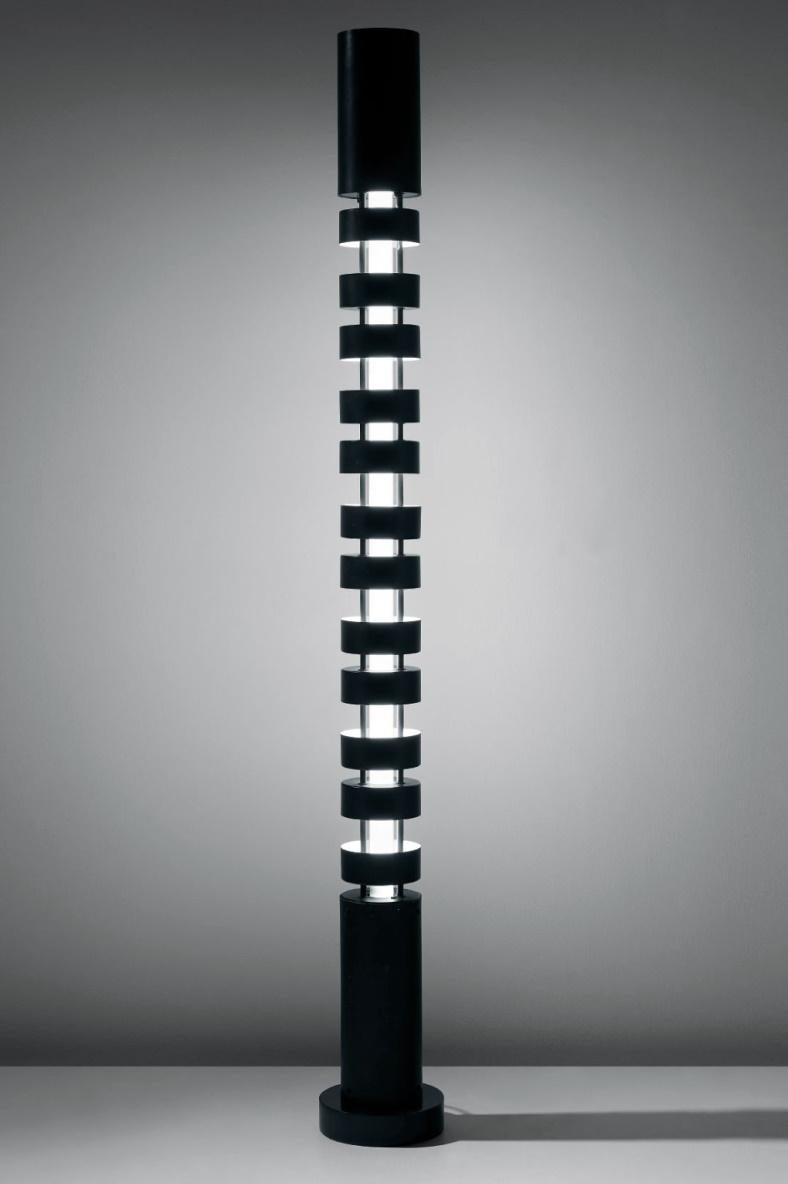 Nel periodo Post Black Shapes, Serge Mouille sperimenta con il colore e le colonne. Con il Totem, ha impilato paralumi cilindrici intorno a un elemento di illuminazione centrale. Alternando le tende verso l'alto o verso il basso, l'intensità della