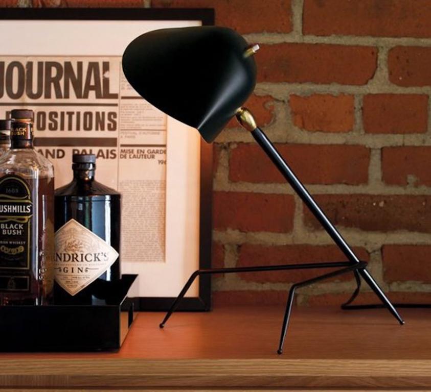 Serge Mouille 'Lampe Tripode' table lamp in black. Originally designed in 1954, this iconic lamp is still made by Edition Serge Mouille in France using many of the same small-scale manufacturing techniques and scrupulous attention to detail,