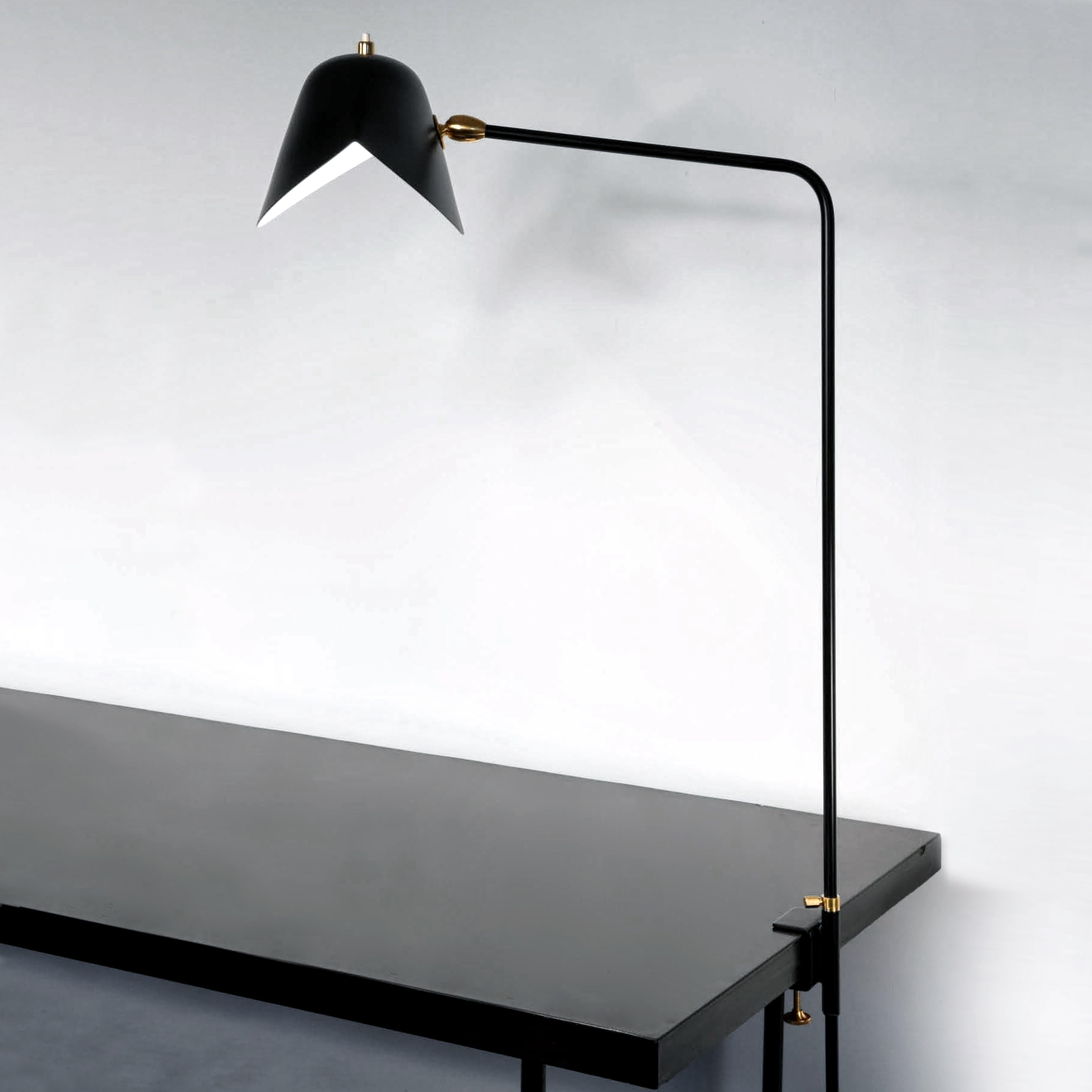 Modèle de lampe de table 'Simple Agrafée table lamp' conçu par Serge Mouille en 1957.

Fabriqué par les Editions Serge Mouille en France. La production des lampes, des appliques et des lampadaires est réalisée de manière artisanale avec les mêmes