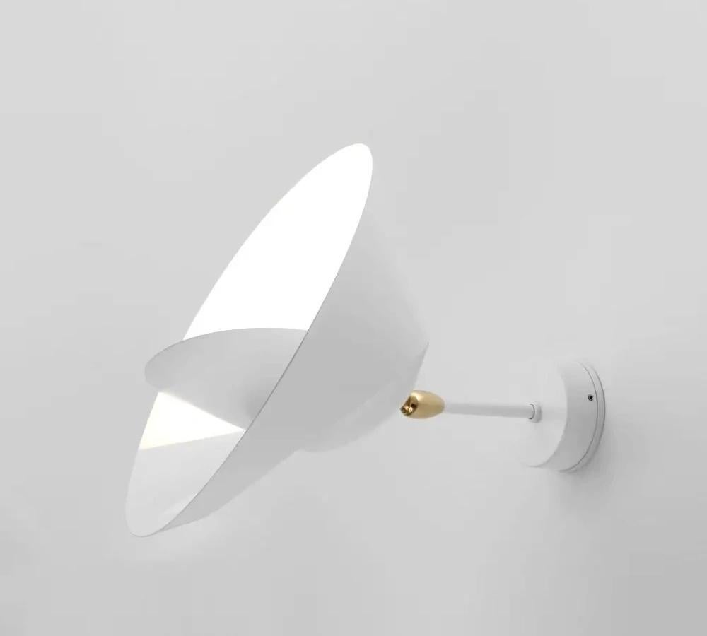A partial cut allows the outer edge to bend revealing a sculpted ring encircling a central cone reflector to both diffuse and project light into the room. The result is reminiscent of a heavenly body.

Painted aluminum and steel with brass