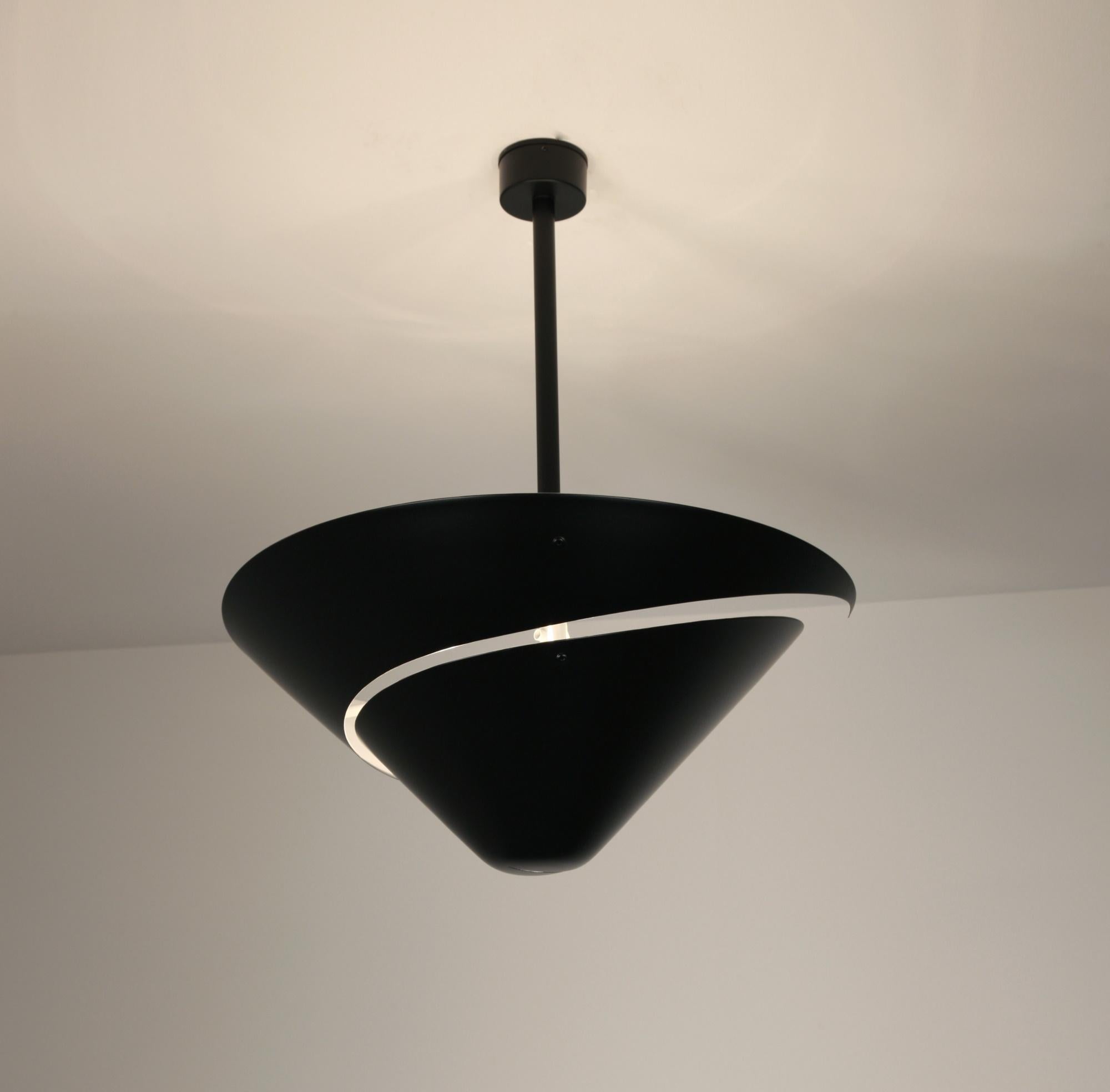 A snail shell provides the inspiration for this lamp with its swirling cut out in the circular shade. Light projects downward through the opening while the shade causes light to reflect from the ceiling.

Custom drop lengths upon approval.