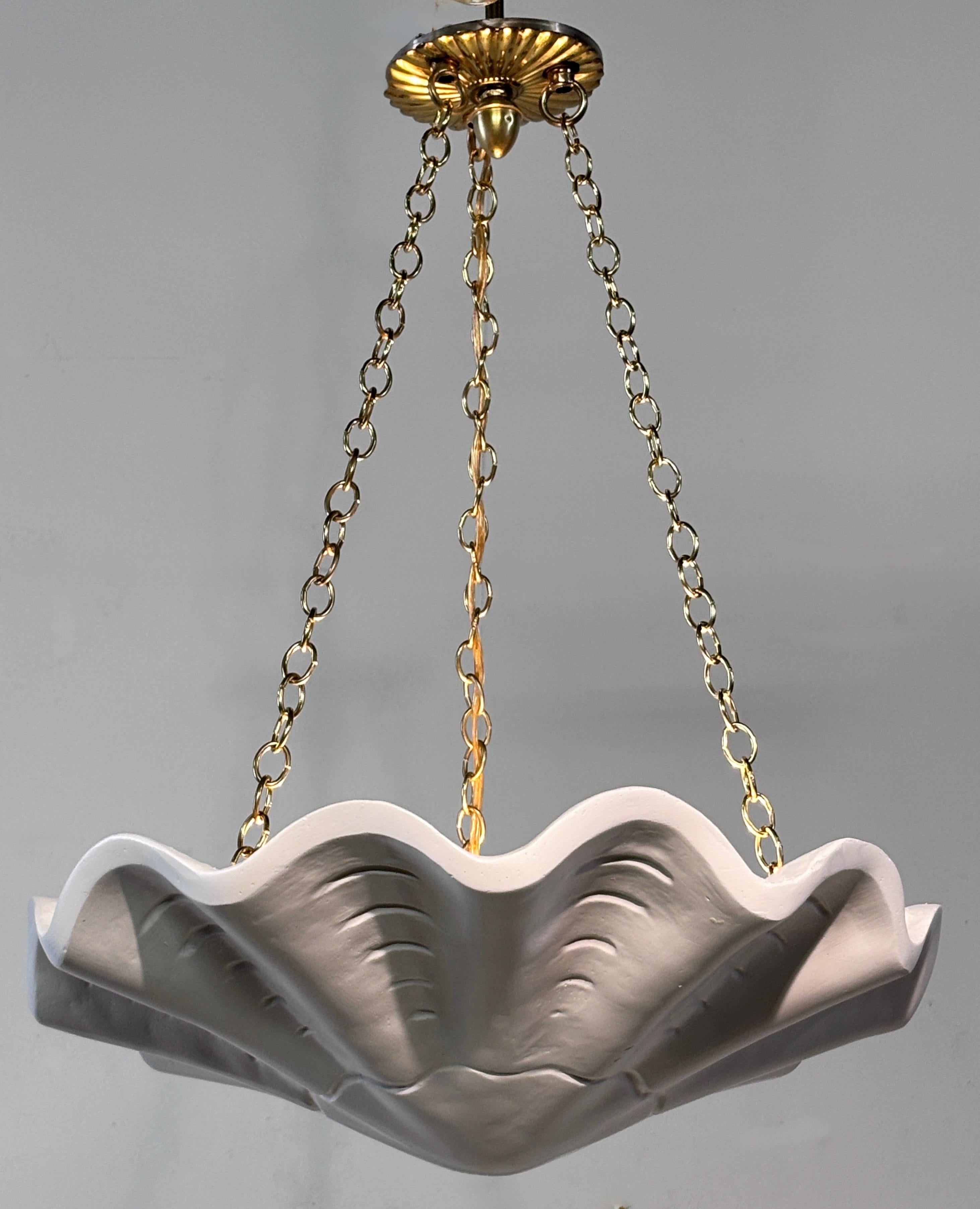 Plafoniera a sospensione in stile Serge Roche. Il fulcro di questa lampada a sospensione è il grande faretto, che ha la forma di una grande conchiglia. Elegante e sofisticato, cattura l'essenza dell'estetica iconica di Roche.
Recentemente è stato