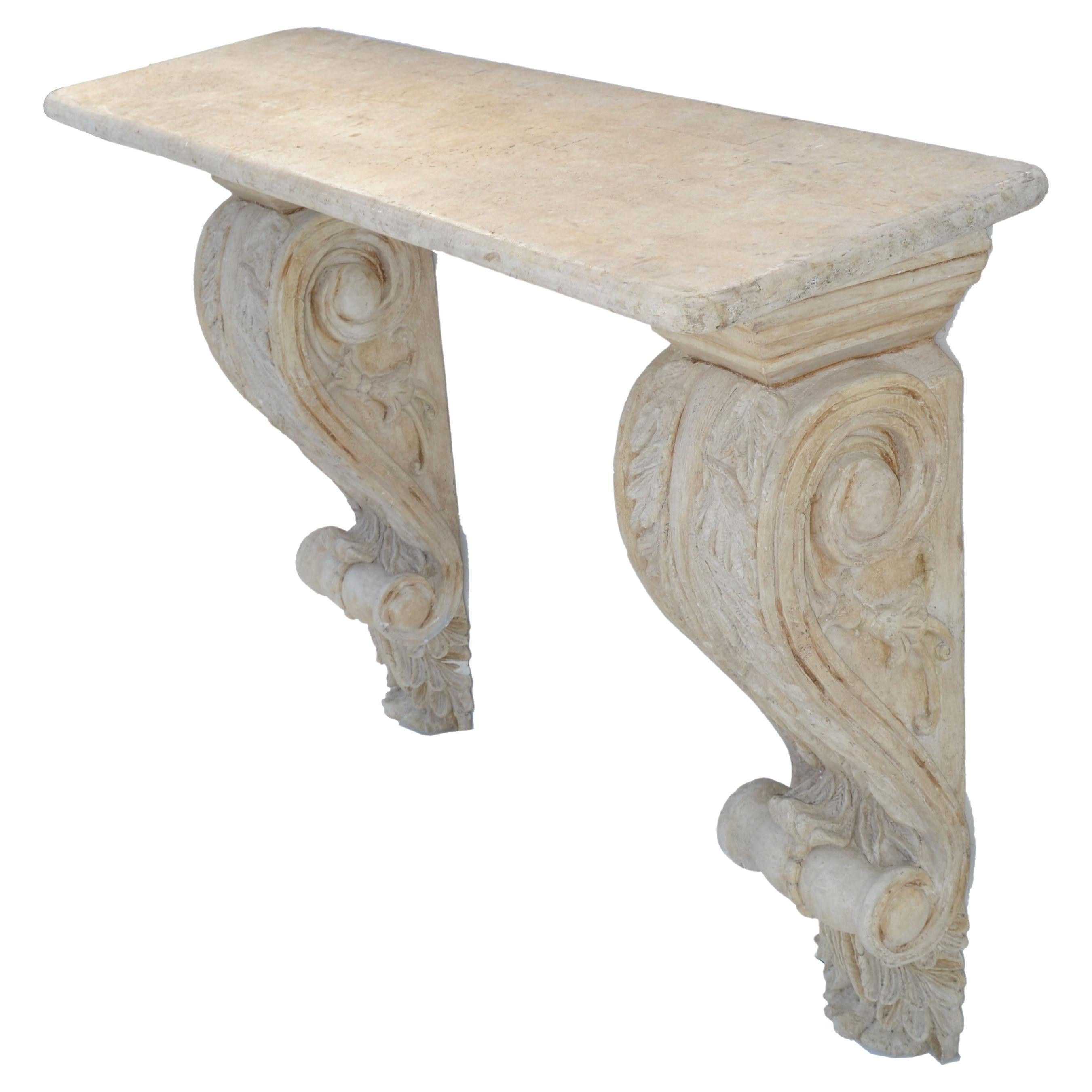 Large wall mounted console table or shelf in the style of Serge Roche made in France in the 1950.
Scrolled and hand carved wall brackets made out of Plaster holding the taupe color faux marble wood and stone top.
Mounting hardware included.
In