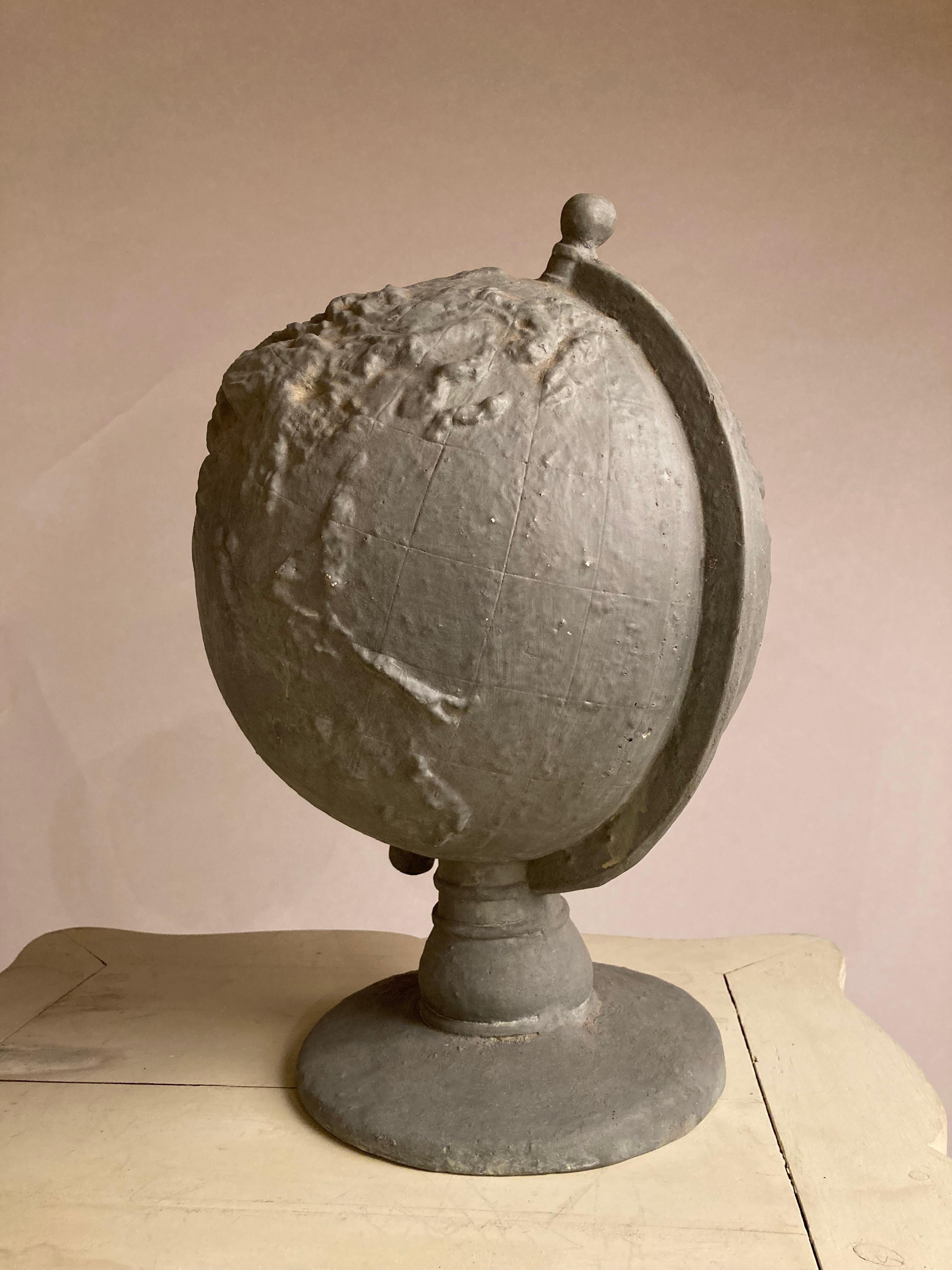 Very cool gray painted plaster topographical globe on stand of the planet earth, showing prominently the various mountain ranges, Andes, Rockies, Himalayas etc. Unusual piece, style of Serge Roche. 
Measures: 19 inches high 13 diameter.