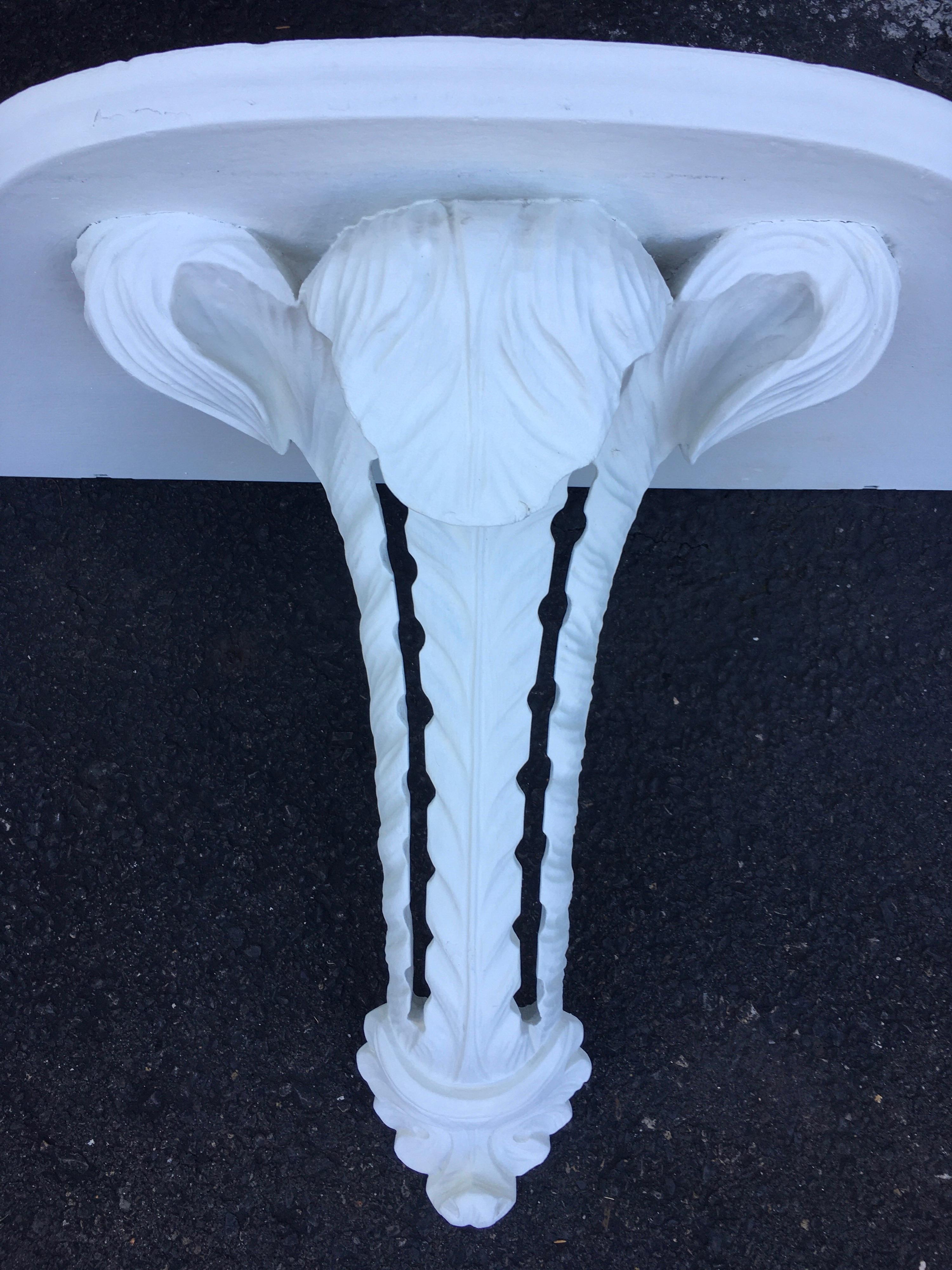 Hollywood Regency Serge Roche style wall mount console shelf. This large sculptural carved wood bracket features a scrolled plume design in a matte white plaster-like painted finish.