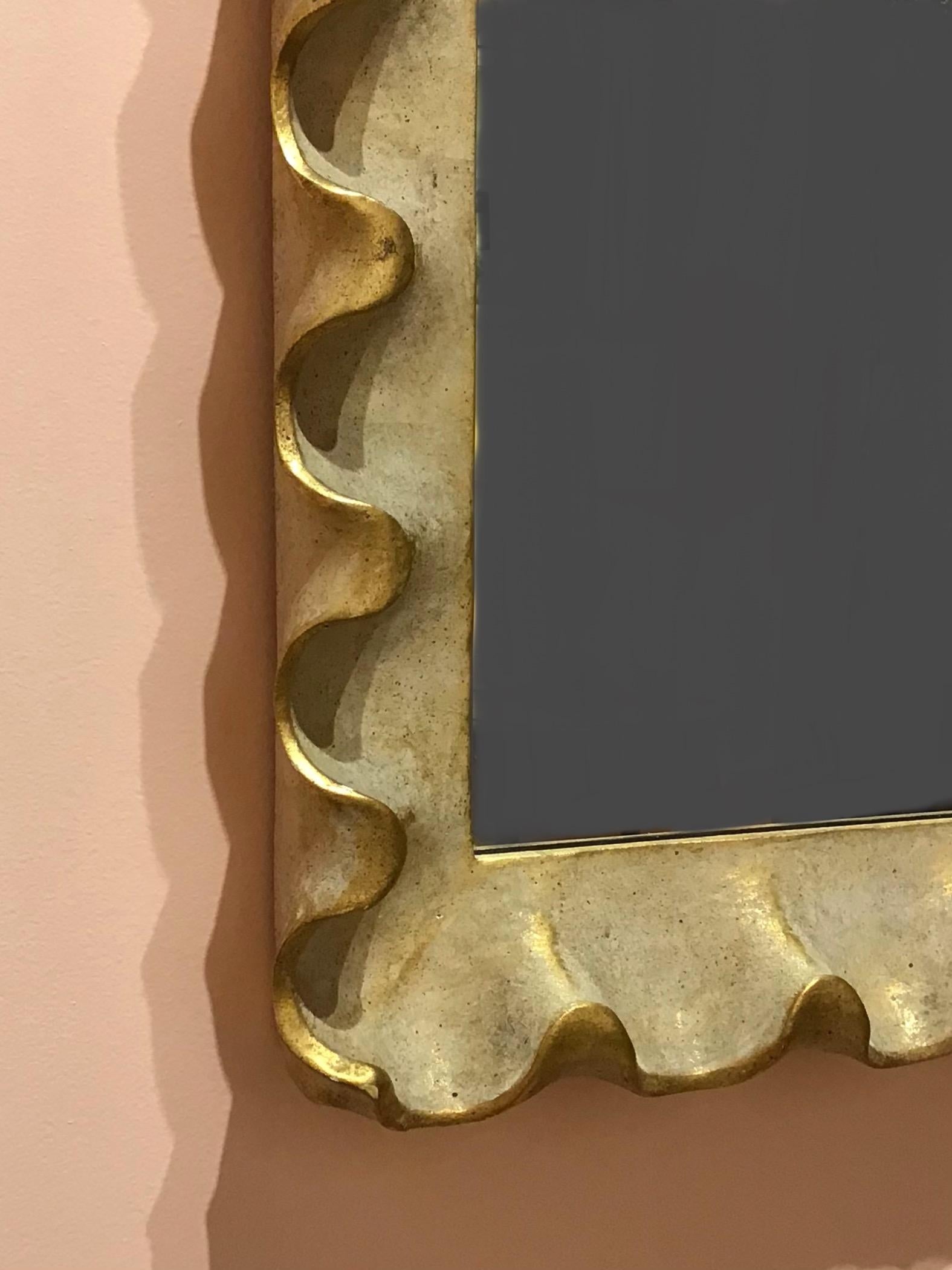 Large scalloped mirror in the manner of Serge Roche. Gilt gesso over carved wood with a pale pink soda wash finish said to have been popularized by Wildenstein Galleries in the 1950s.