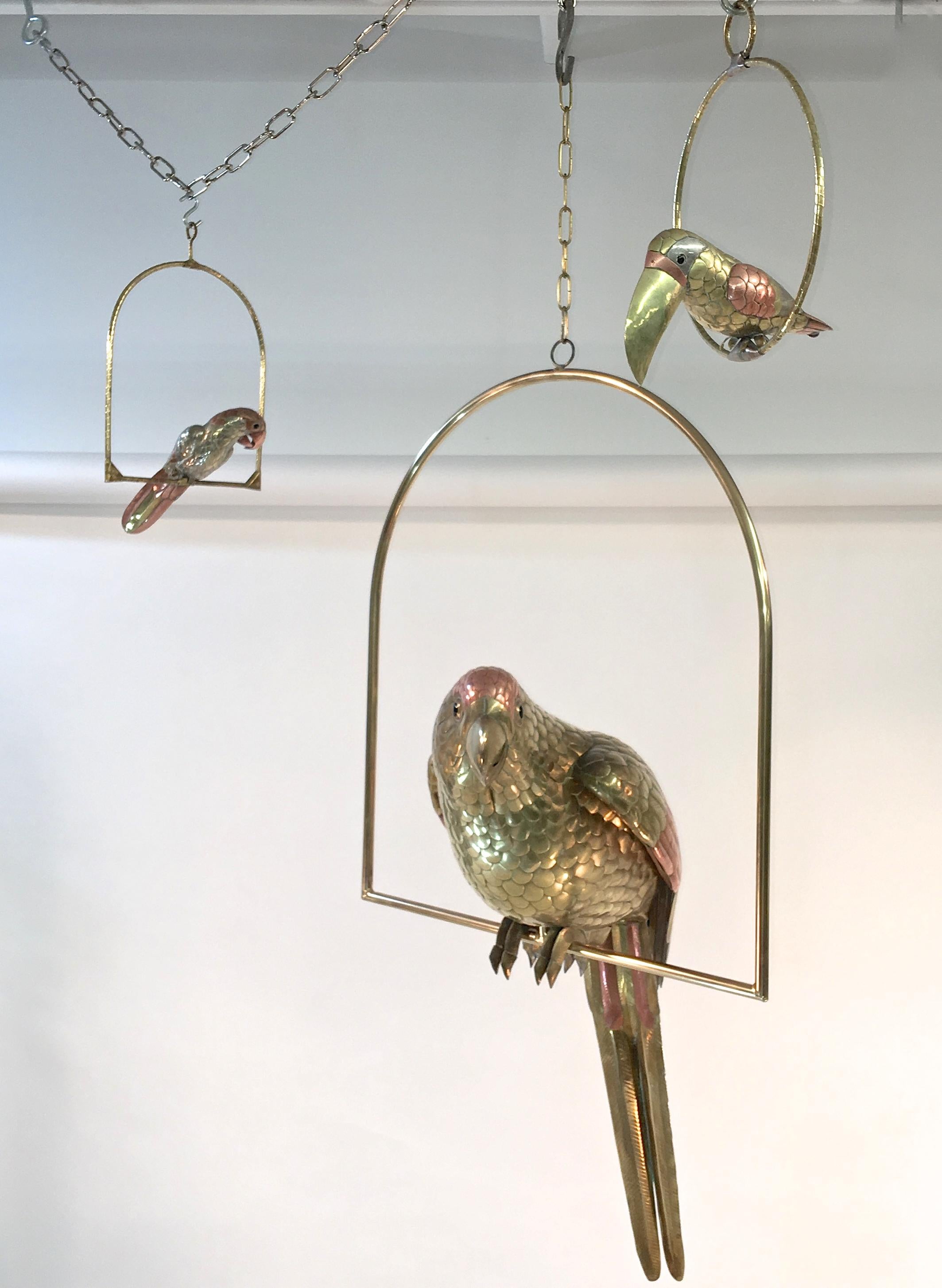 The craftsmanship and vitality of Bustamante's birds is astonishing.

Presented here is a group of three; one large parrot, one small parrot and one toucan, Mexico, 1960s.

Handcrafted from brass and copper. The small parrot also has