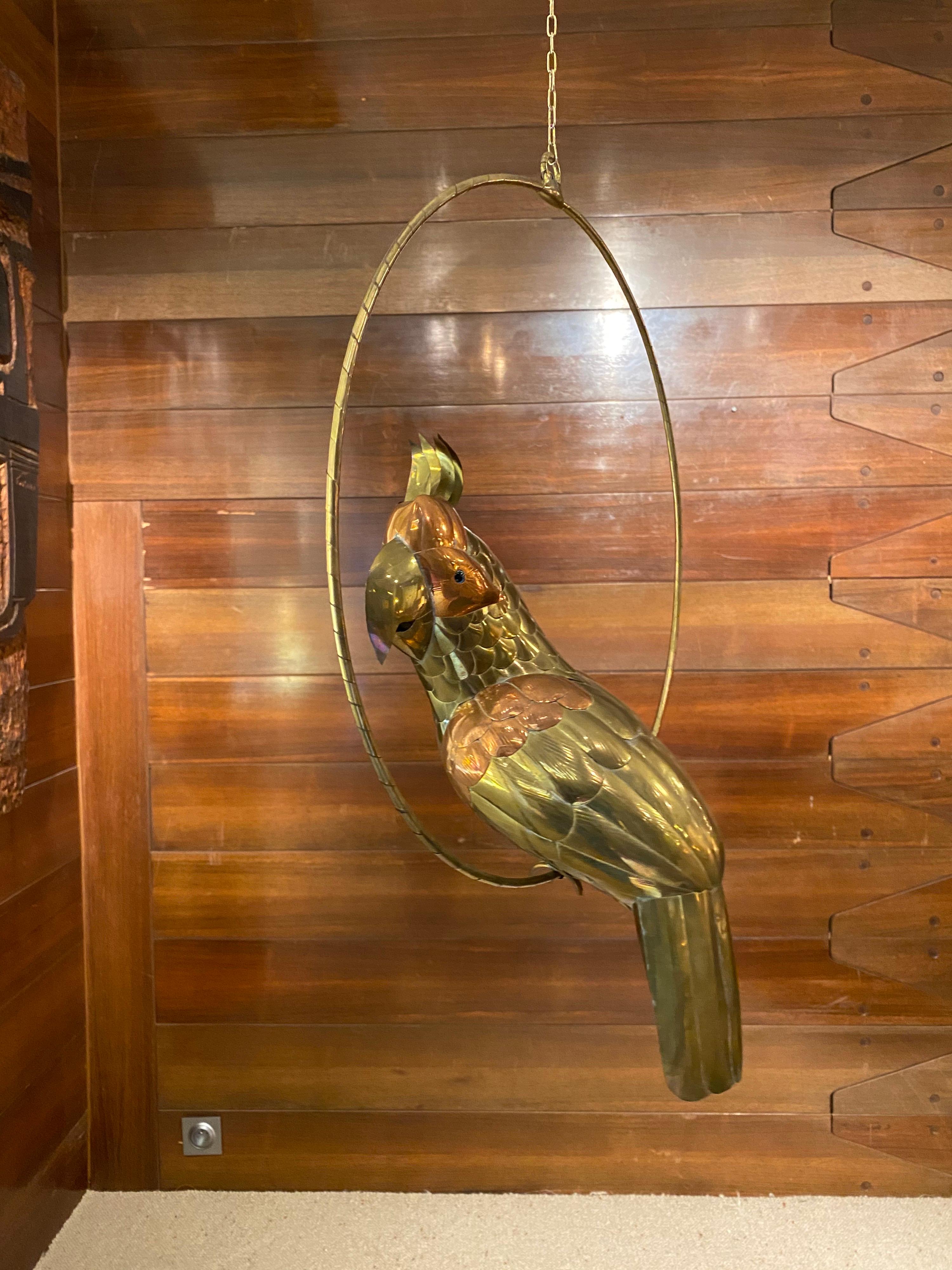Large parrot on his perch made of copper and brass to give variety of colors and texture to this bird.
Designed by Sergio Bustamante (Mexican designer) who was famous for his depictions of animals.
He still bring imagination and surrealism to his