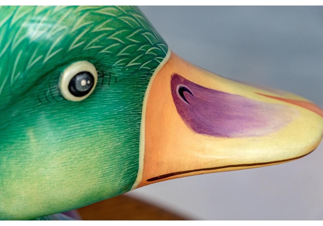 Un grand canard en papier mâché coloré et saisissant de Sergio Bustamante. Cette sculpture ronde représente un canard peint à la main dans des tons bleus, avec des ailes aux couleurs pastel (rose, violet, bleu et or) et une tête d'un vert