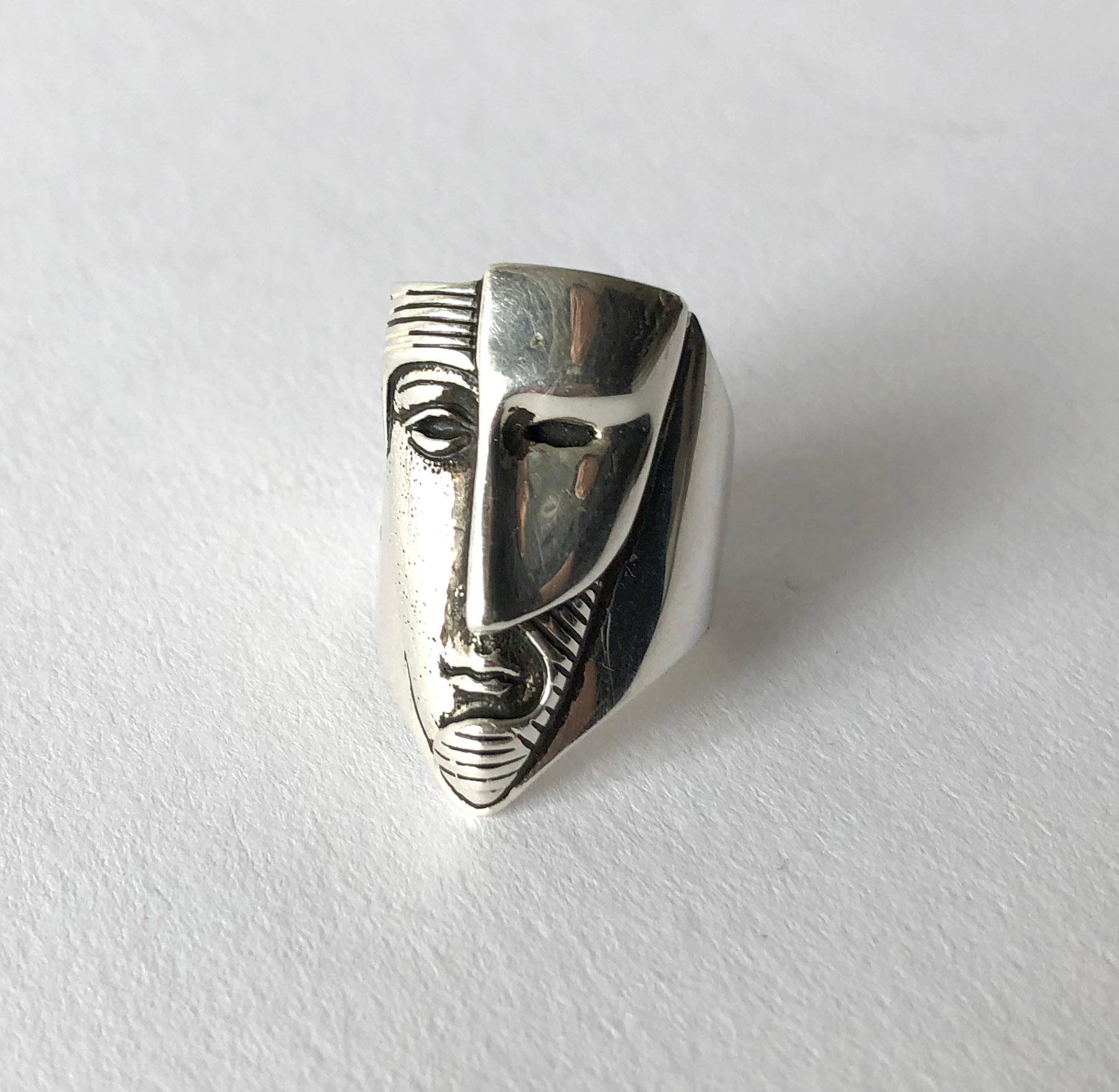 Mexican modernist sterling silver face with mask ring created by sculptor and jeweler Sergio Bustamante.  Ring is a finger size 6.  The face of the ring measures 1 1/8