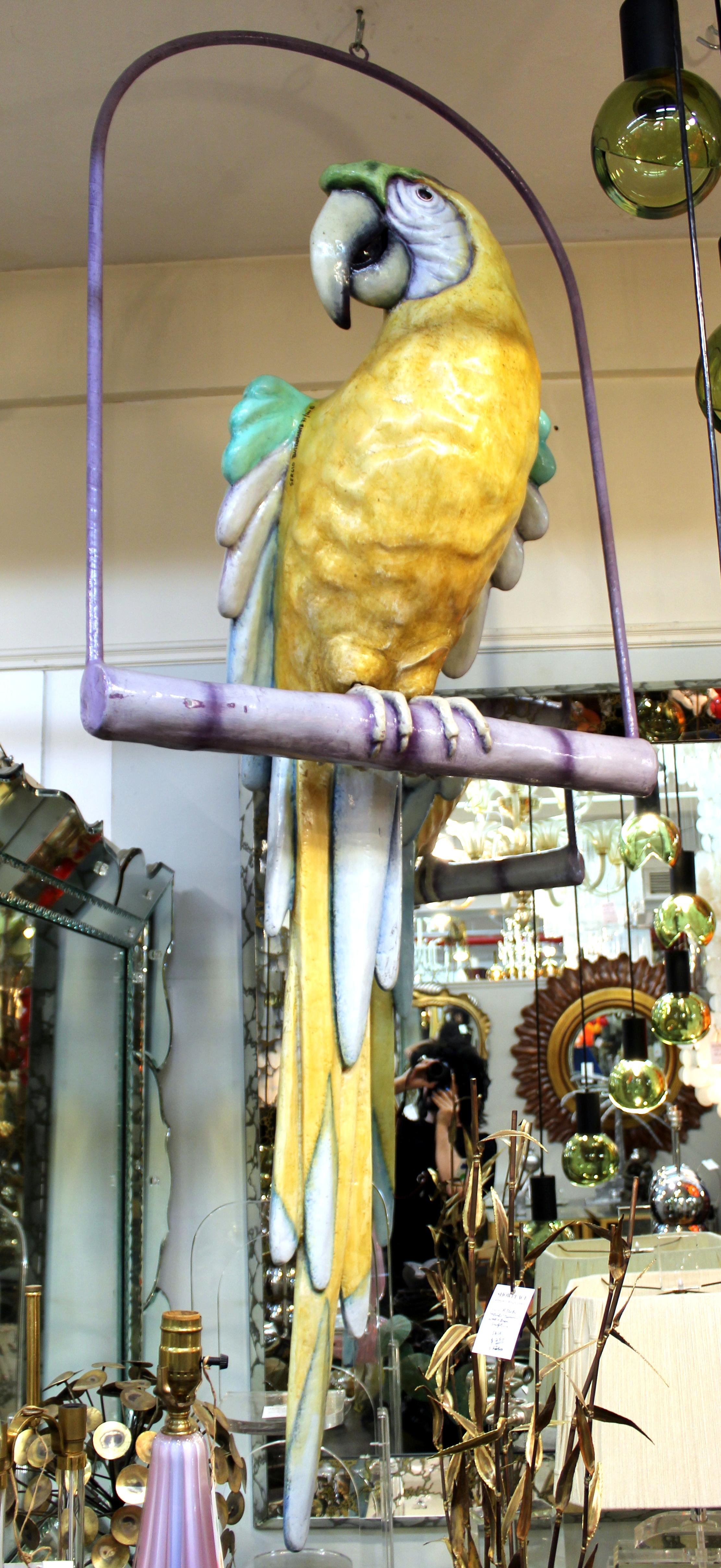 Monumental Modern papier-mache parrot on a perch, made by Sergio Bustamante. The colorful parrot can be removed from its perch. The piece is signed on its proper right shoulder and is in great vintage condition with age-appropriate wear.