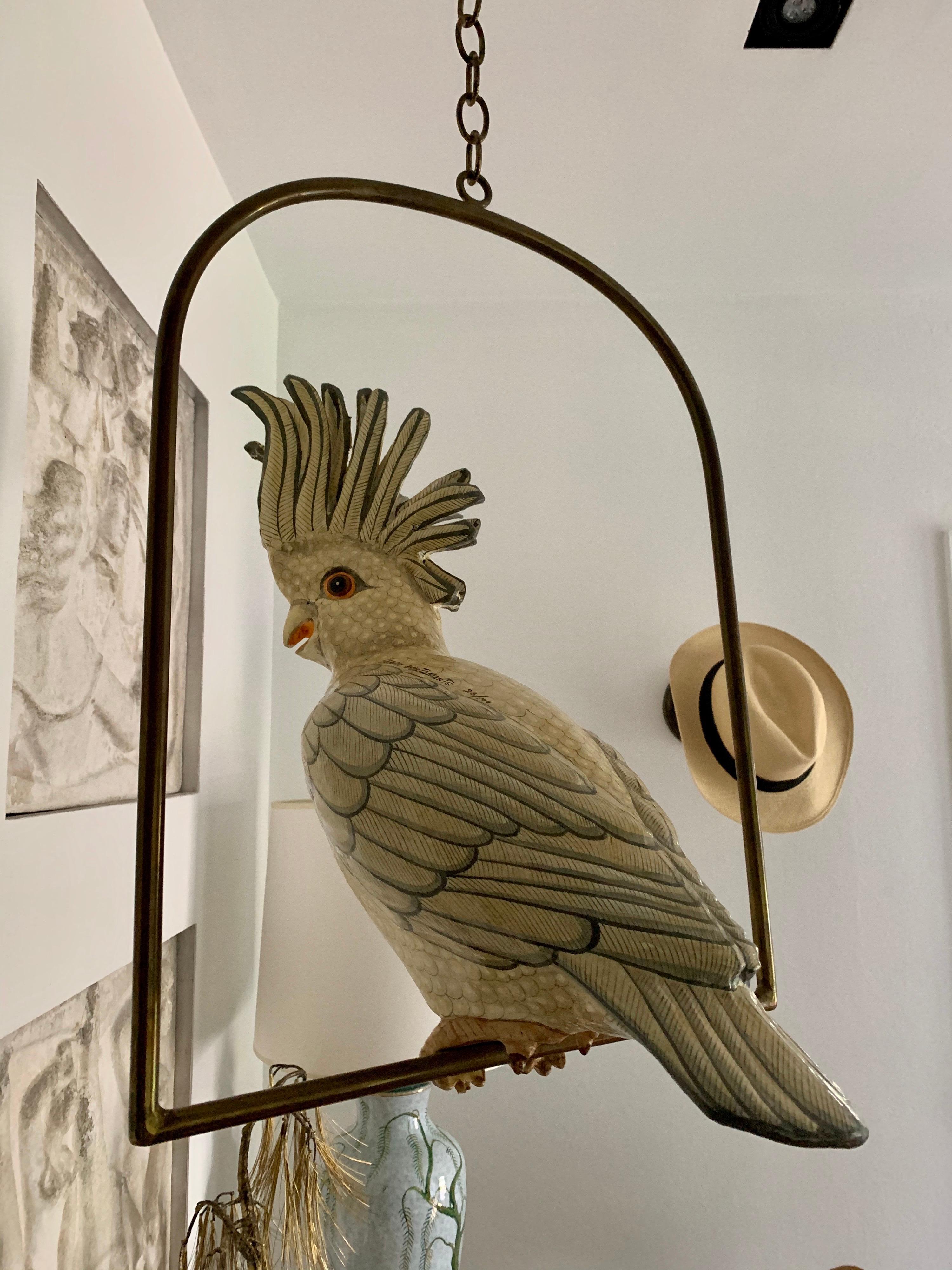 This is a limited edition series 26/100 papier mâché cockatoo sculpture by famed and highly collected Mexican artist, Sergio Bustamante. This large bird sits perfectly on the brass perch and can be hung at varying heights base on your needs. Total