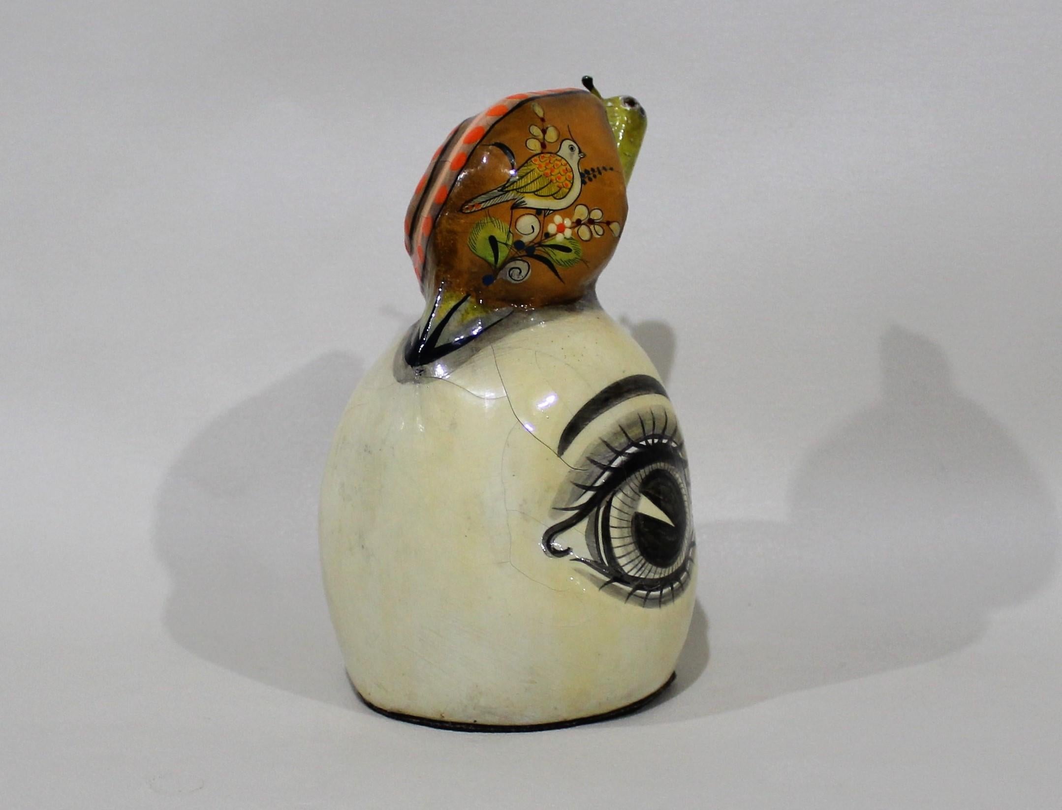 Sergio Bustamante papier mache sculpture of snail sitting atop eyeball.