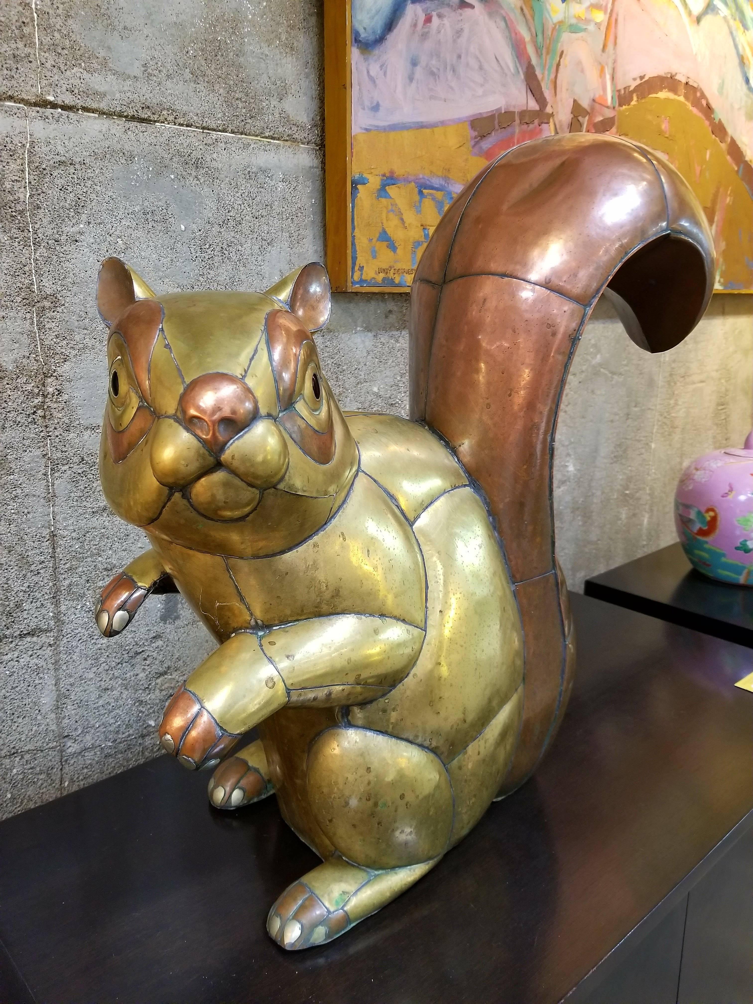 A mixed metal copper and brass squirrel sculpture by Sergio Bustamante. Measures: Stands 23.5
