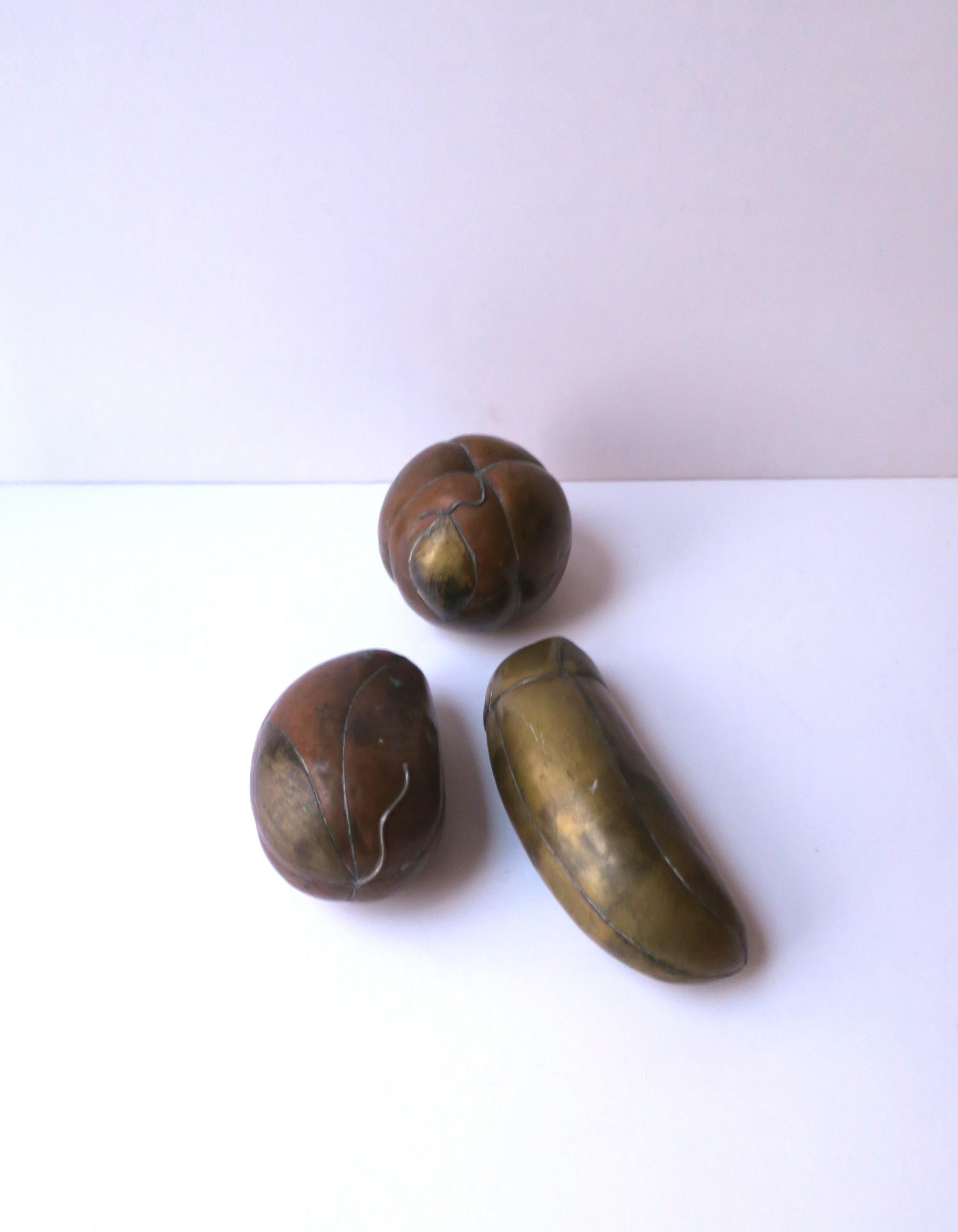 A nicely weighted set of three (3) brass and copper fruit vegetable sculptures in the style of Sergio Bustamante (b.1924 - d.2013), circa mid to late-20th century, 1960s, 1970s. Set is shown with patina, unpolished. A great set to display on a