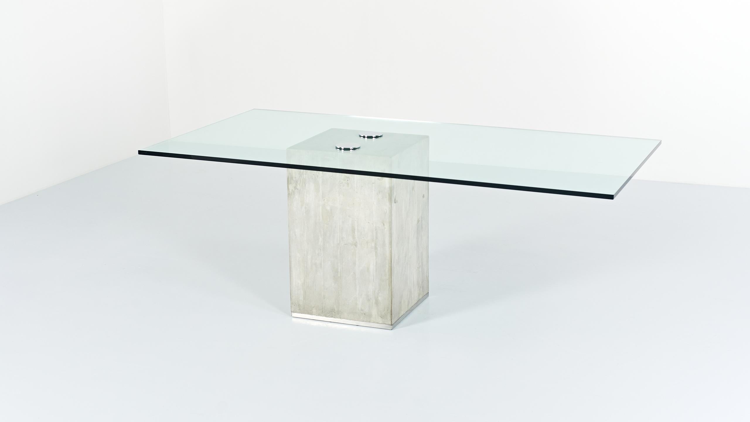 A glass and concrete dining table, model “Sapo”, by Italian designers Sergio and Giorgio Saporiti. Glass table top (19mm thick) supported by a concrete base enhanced with a flat chromed rod at the bottom. Small traces of use, very good overall