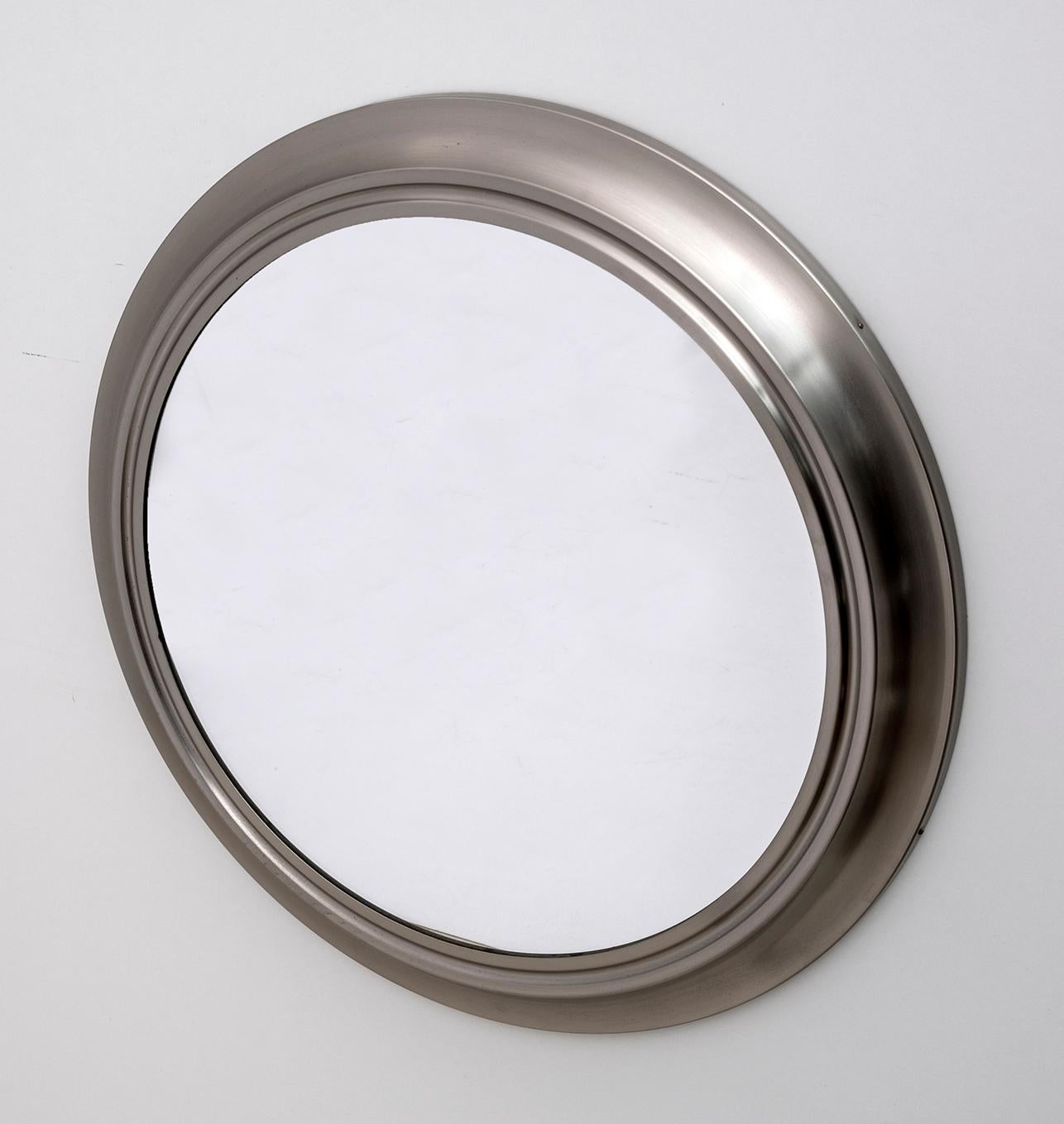 Wonderful round aluminum mirror attributed to Sergio Mazza for Artemide. This fantastic object was produced in Italy in the 1960s. This piece has a wonderful modernist corrugated aluminum frame, which has a concave center that creates depth and