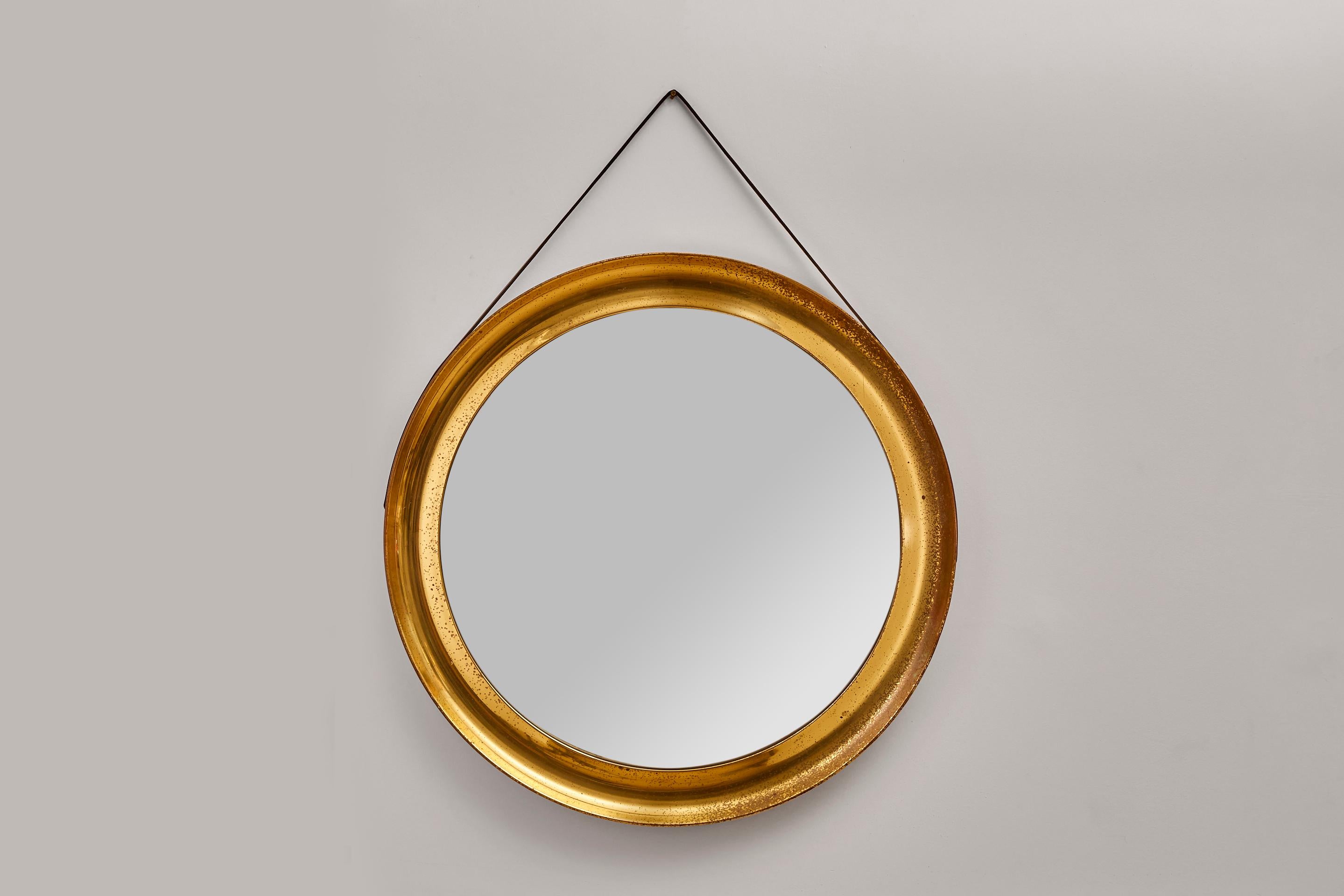 1960's Italian circular 'Narciso' mirror with a brass frame and leather strap.

Designed by Sergio Mazza for Artemide, the mirror and brass have a lovely authentic patina.

The patina around the frame elevates the beauty extenuating the vintage