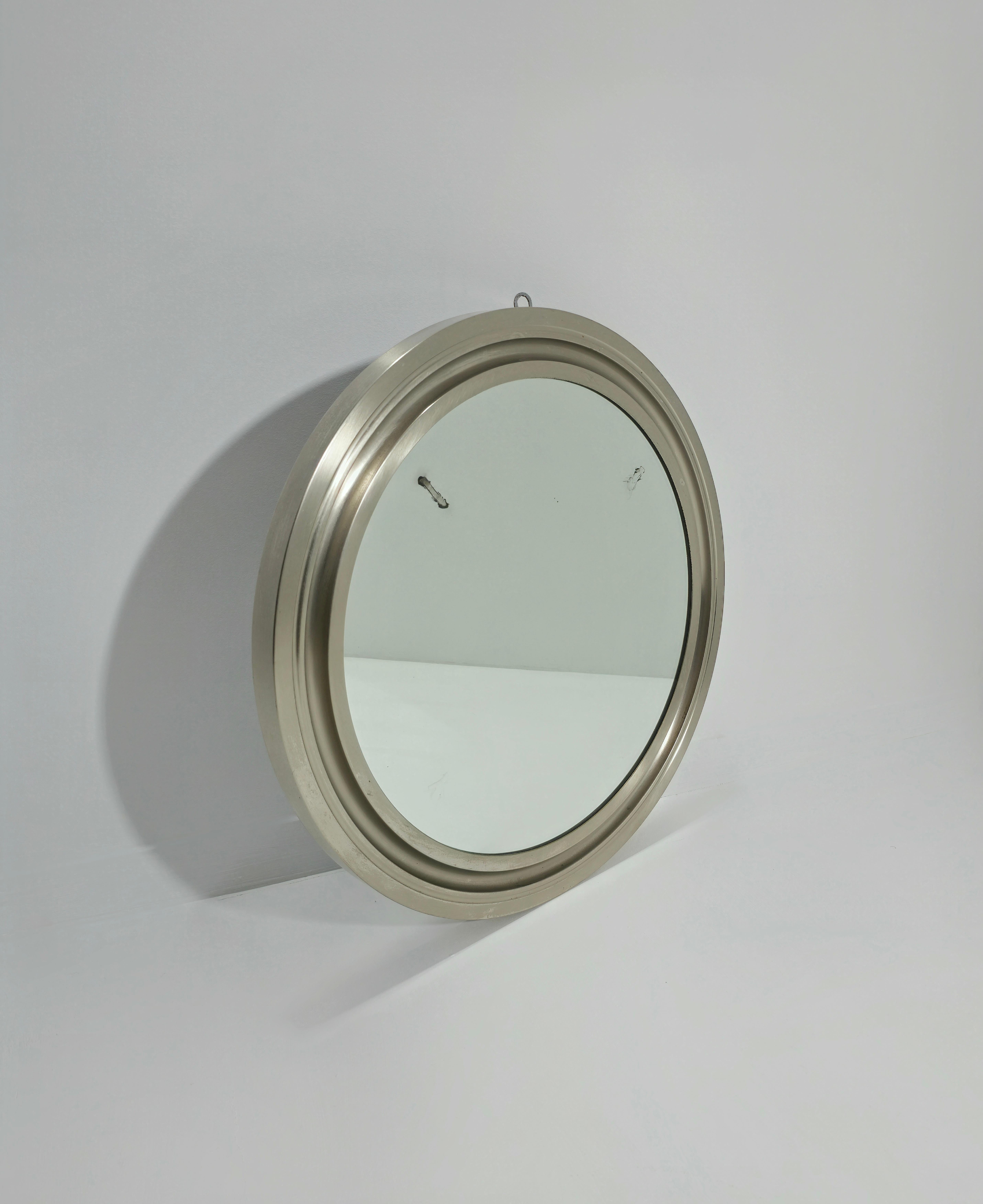 Wall mirror designed by Sergio Mazza with a round shape entirely in galvanized aluminum. Italian production of the 1970s. This simple mirror is quite surprising and modern, a real joy for a living room. Please watch the video and photos carefully,