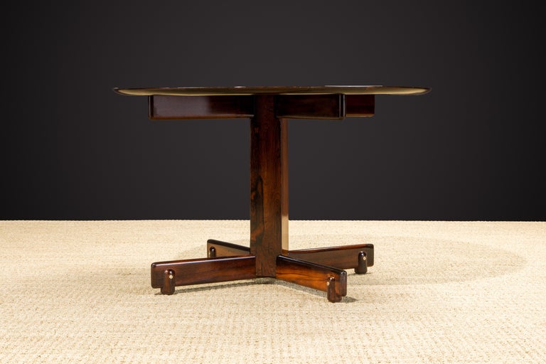 This gorgeous 1960s Jacaranda Rosewood dining table by Sergio Rodrigues, named the 'Alex' table, features one of the most vivid and vibrant Brazilian Rosewood tops that we've ever seen, restored with a French Polish which is the most expensive and