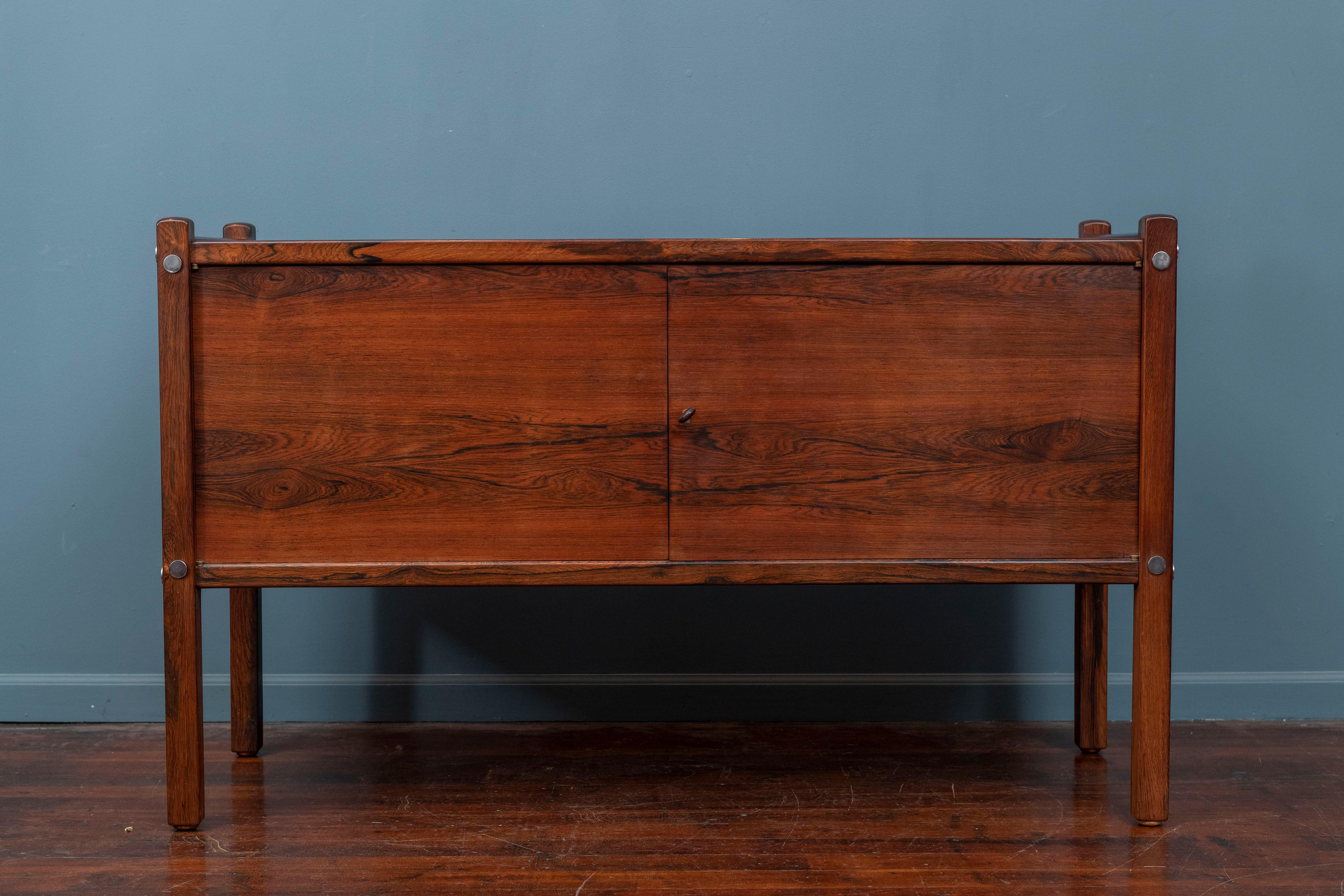 Sergio Rodrigues design credenza for OCA, Brazil. Made from Jacaranda wood with silver medallions and two interior shelves. Beautiful studio craftsmanship throughout, stamped with the original key. 
In original condition with light signs of wear to