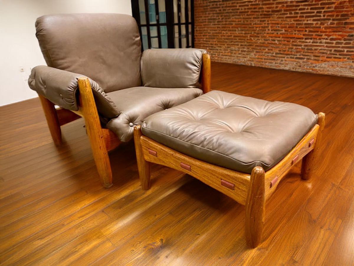 Brazilian modern Sergio Rodrigues 'Sheriff' lounge chair with ottoman in brown leather, circa 1960s. This mid-century modern lounge chair has been reupholstered and leather straps have been replaced on both the chair and ottoman. 
Dimensions: