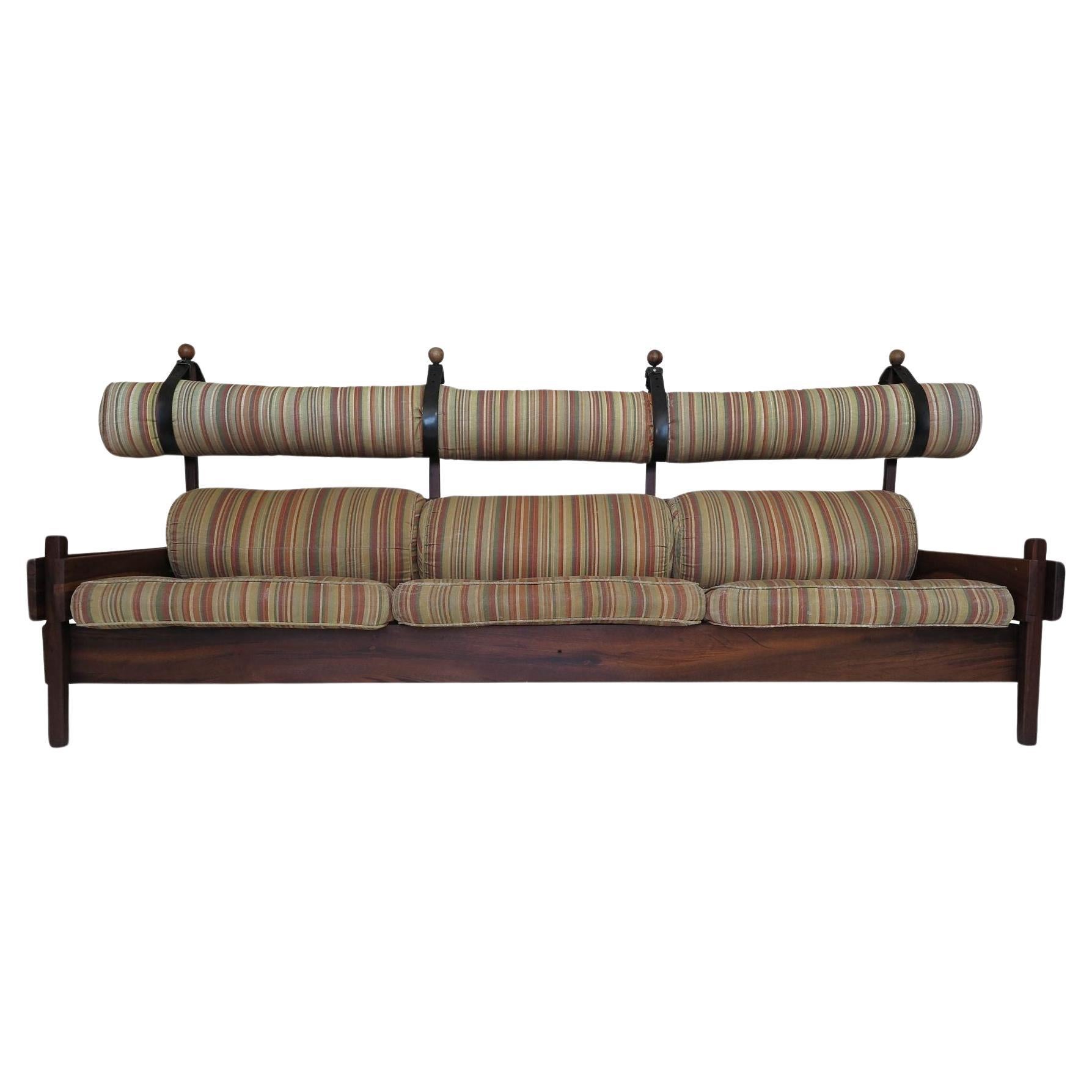 The Sergio Rodrigues Tonico sofa, produced by OCA/Meia-Pataca in 1962, features a frame constructed of solid Pau Ferro wood, a Brazilian hardwood known for its beautiful reddish-brown color, fine texture, and durability. The original cushions,