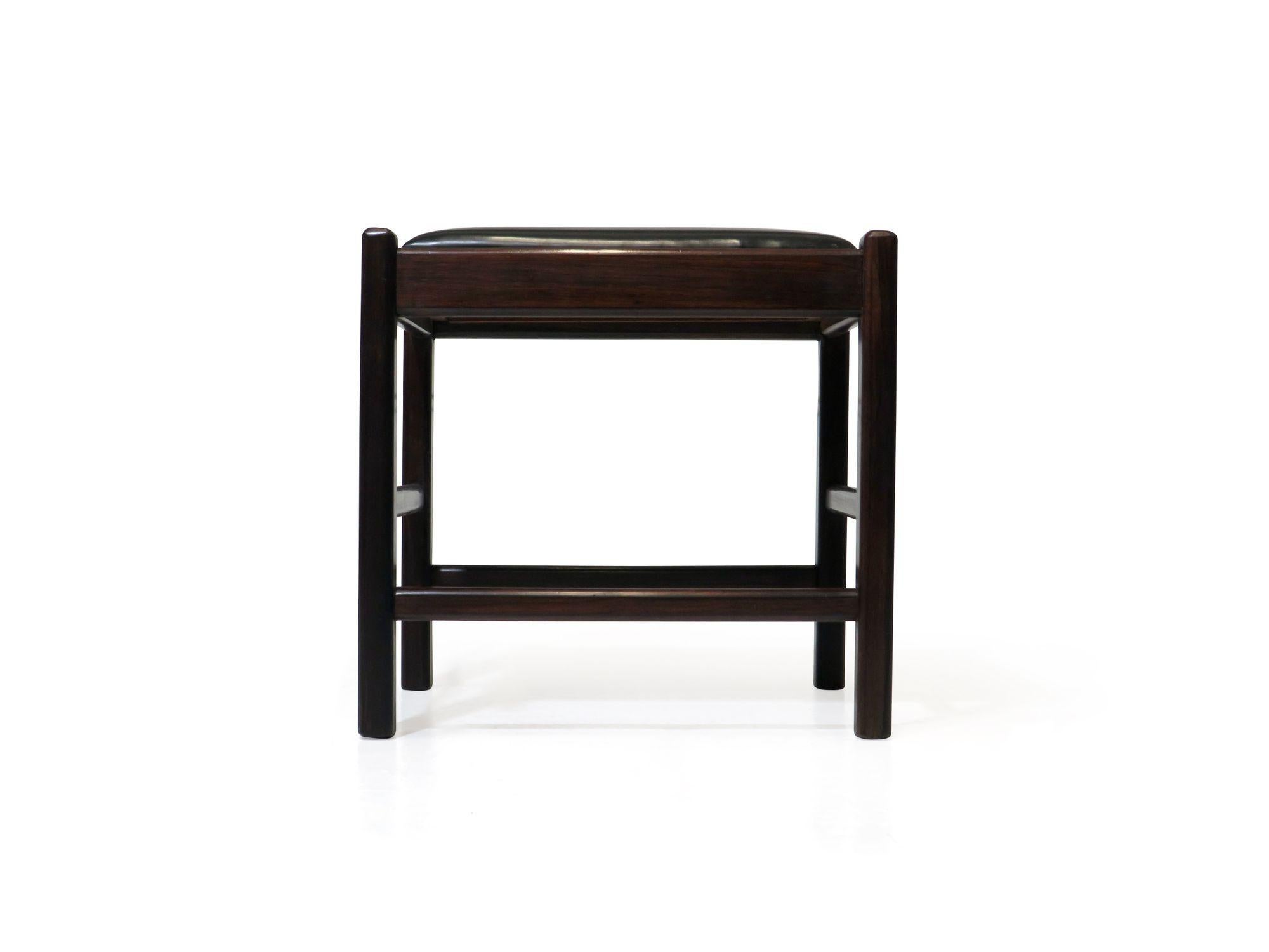 Brazilian rosewood bench designed by Sergio Rodriguez crafted of solid, dark brazilian rosewood and upholstred in the original black vinyl. Sturdy.