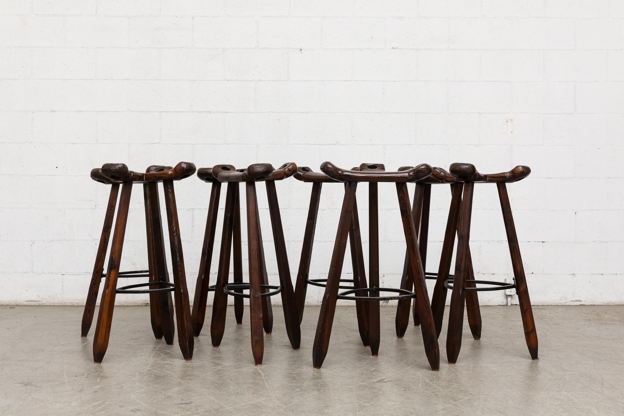 Sergio Rodrigues style Brutalist bar stools, primitively carved and lightly refinished dark oak with black iron footrests. Other similar styles available and listed separately.