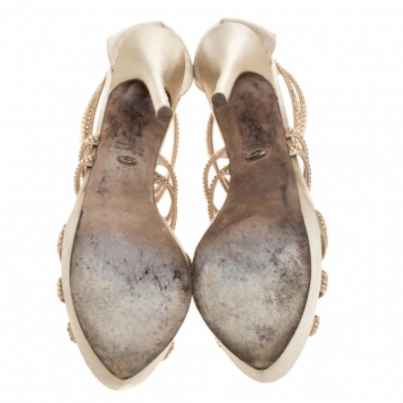 Designed in a strappy silhouette with cut-out details and crystal embellishments, these gorgeous sandals from Sergio Rossi are here to shine! They are crafted from beige satin and styled with open toes, zippers on the counters, solid platforms, and