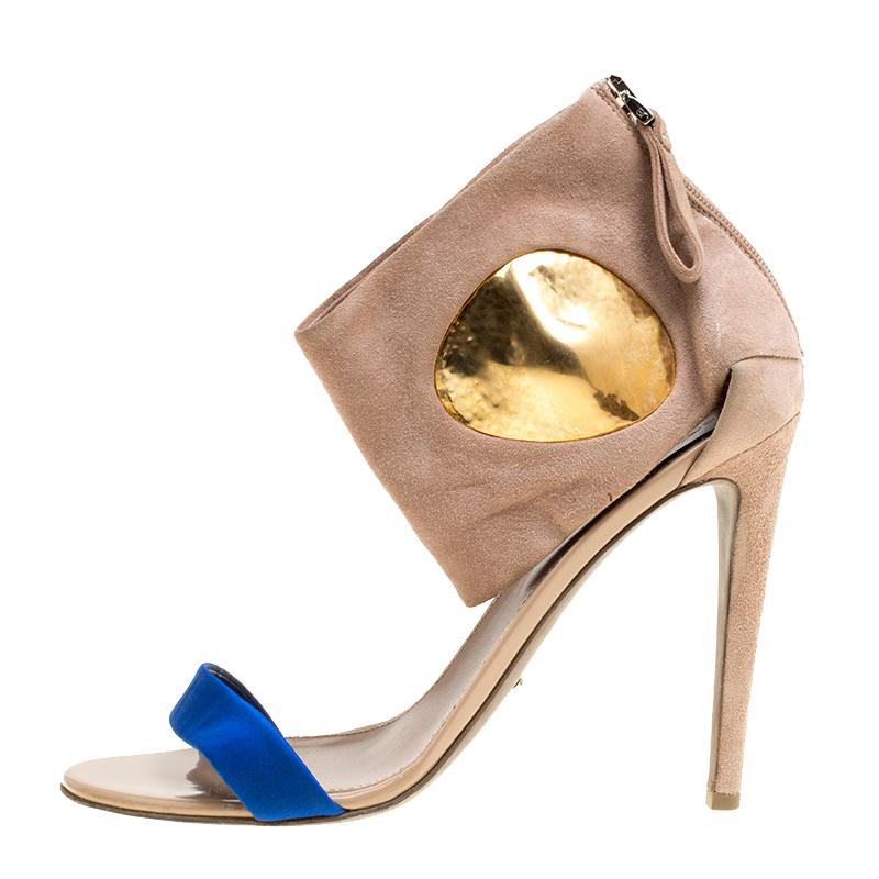 You'll leave the crowds amazed when you step out in these stunning sandals from Sergio Rossi. These beige sandals are crafted from suede and featurn an open toe silhouette. They flaunt a blue satin vamp strap and ankle cuffs with gold-tone