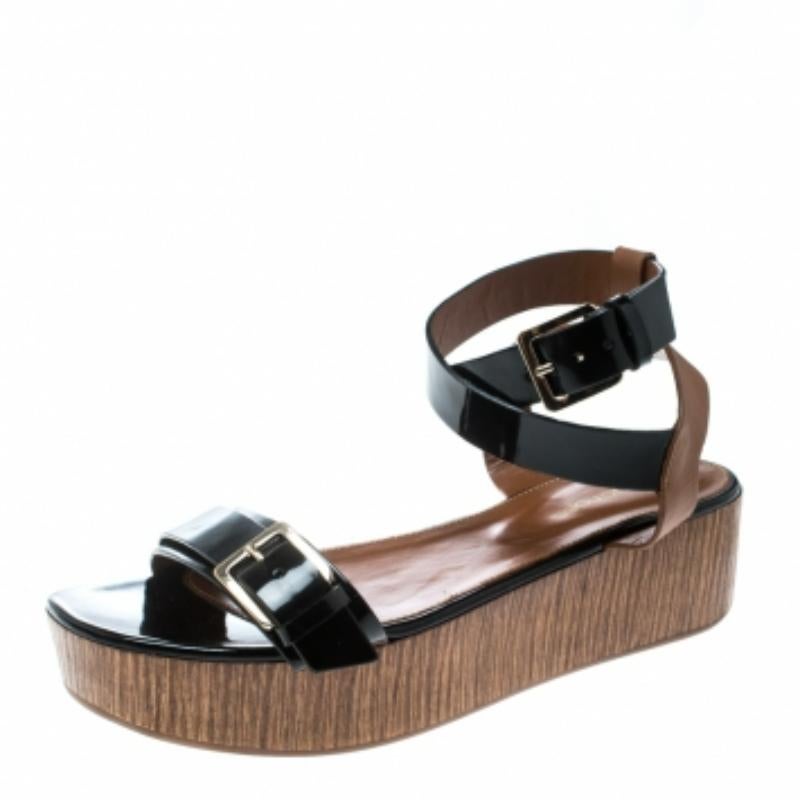 Ces magnifiques sandales de Sergio Rossi complèteront élégamment votre collection de chaussures. Ces sandales noires et marron sont confectionnées en cuir et présentent une silhouette à bout ouvert. Ils sont dotés d'une seule bride à boucle sur le