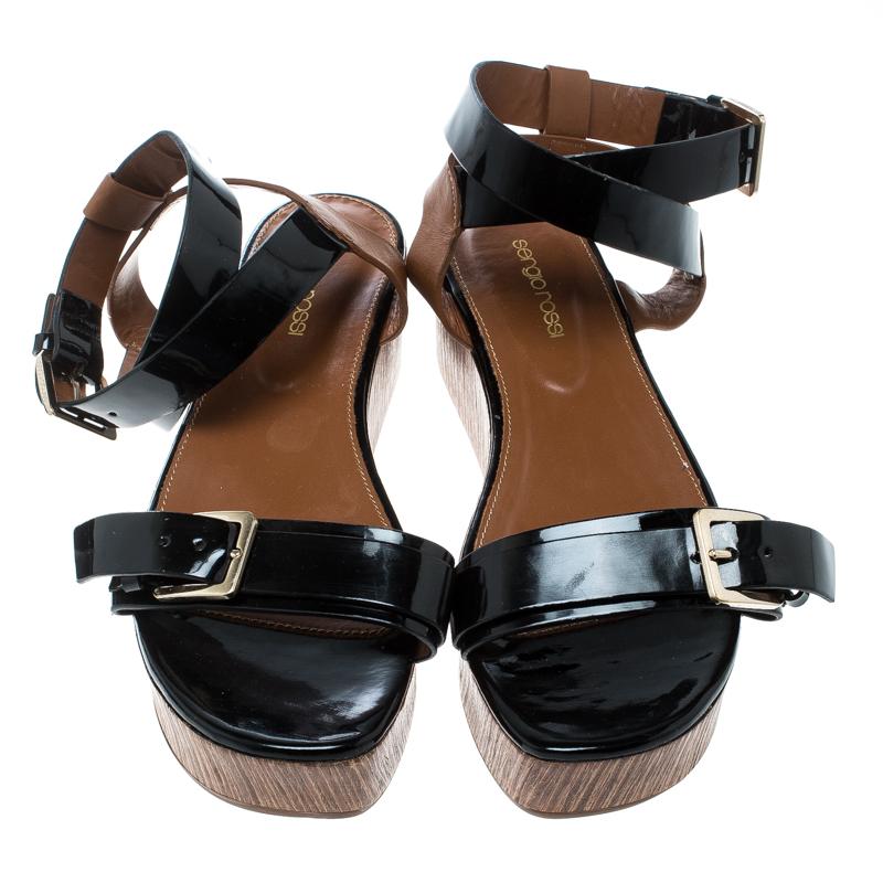 These gorgeous sandals from Sergio Rossi will make an elegant addition to your shoe collection. These black and brown sandals are crafted from leather and feature an open toe silhouette. They flaunt a single buckled front strap, ankle straps,