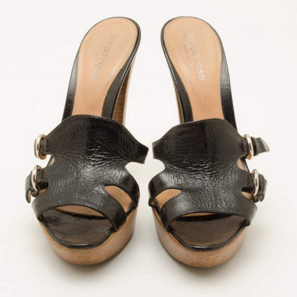 Finish your outfit with these Black Leather Wooden Platform Slides by Sergio Rossi for a edgy and stylish look. Crafted from distressed black leather that is accented with silver buckle detailing and 13 CM wooden platform heels. The insoles are