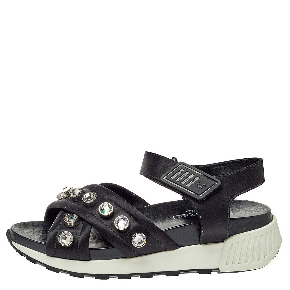 A seamless blend of luxury, sports, and style, these Sergio Rossi sandals are highly comfortable. Crafted from satin, they feature crisscrossed straps adorned with crystals for an opulent finish. These sandals are complete with velcro straps.

