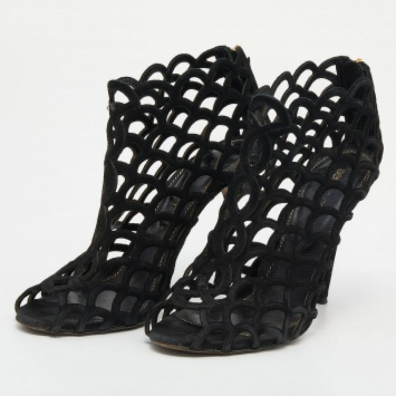 Restez dans le coup avec cette paire de bottines élégantes de la maison Sergio Rossi. Confectionnées en Italie, ces chaussures ont été réalisées en daim de qualité et présentent une élégante silhouette en forme de cage. Elles sont dotées d'orteils