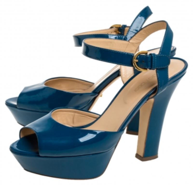 The charm and elegance of these Sergio Rossi sandals will certainly make your heart flutter. They are crafted with patent leather in a pretty blue hue. This stylish pair comes with an ankle strap secured with buckle fastenings, a leather-lined
