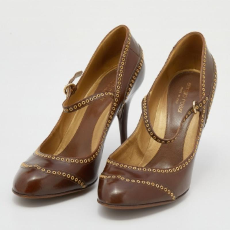 Cammina con grazia con questo paio di décolleté di Sergio Rossi. Disegnate in una tonalità marrone, questo paio di scarpe presenta una decorazione a occhielli sulla tomaia, un cinturino con fibbia alla caviglia e un tacco di 10 cm.