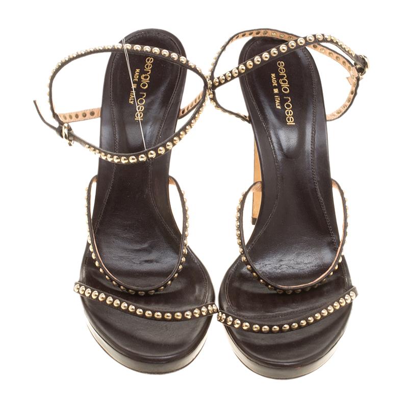 Easy to wear, comfortable and yet effortlessly stylish and glamorous, these Sergio Rossi open toe platform sandals can be paired with both day and night time special looks. Designed in brown strappy leather, these shoes feature gold tone studs all